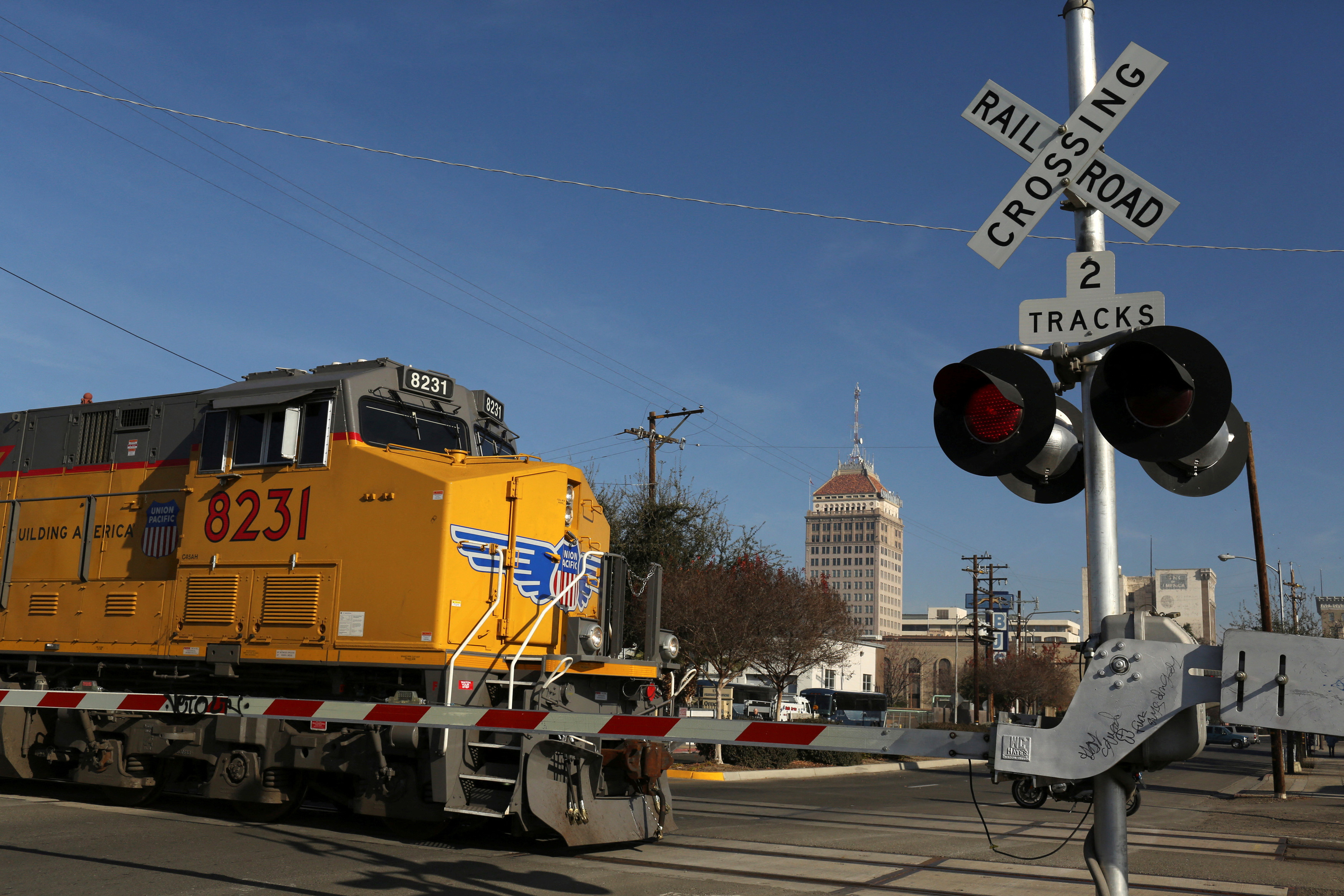 Freight locomotive rolls across an intersection in Fresno