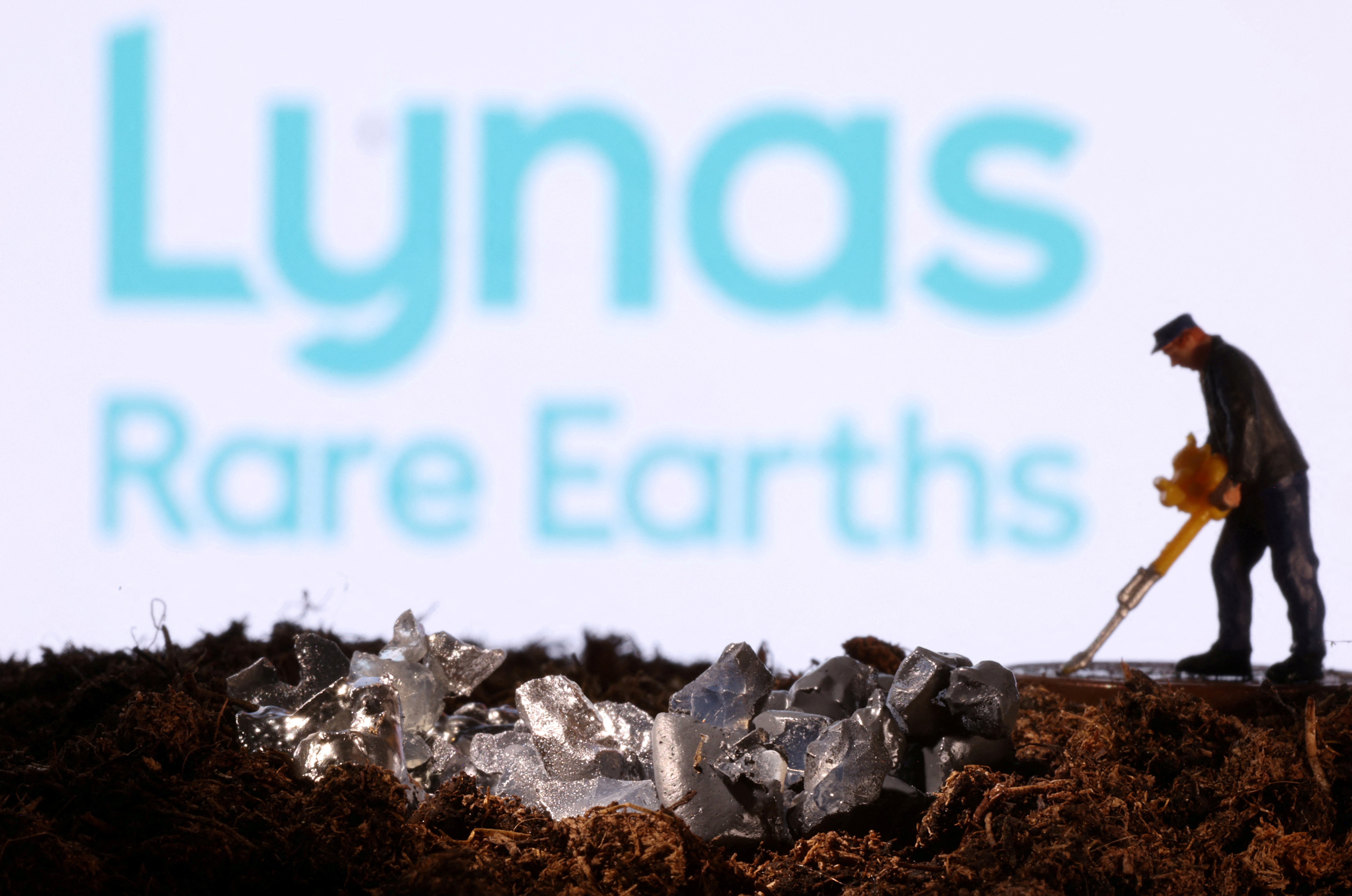 Small toy figure and mineral imitation are seen in front of the Lynas Rare Earths logo in this illustration