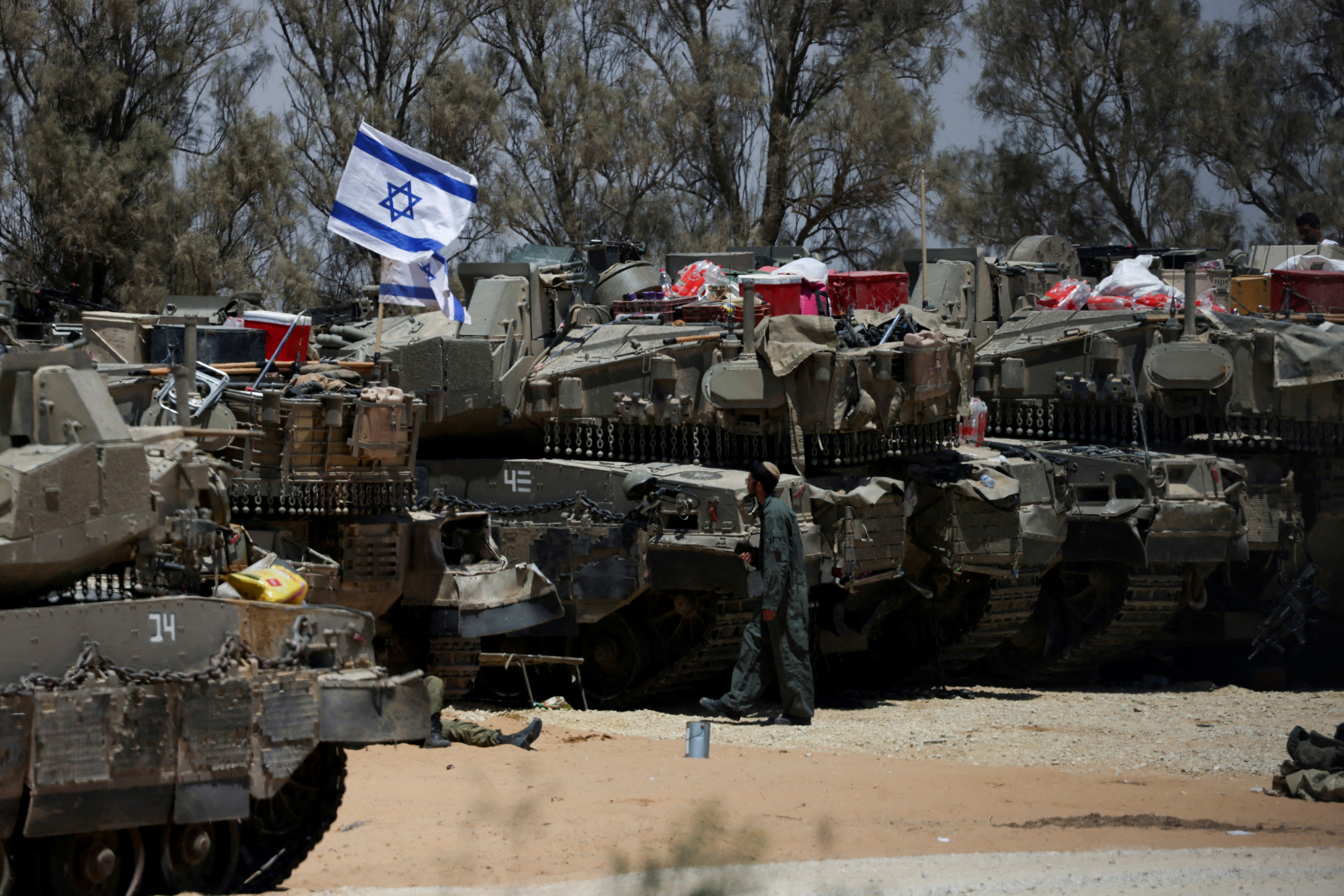 An Israeli soldier walks near military vehicles, amid the ongoing conflict between Israel and the Palestinian Islamist group Hamas, near Israel's border with Gaza in southern Israel