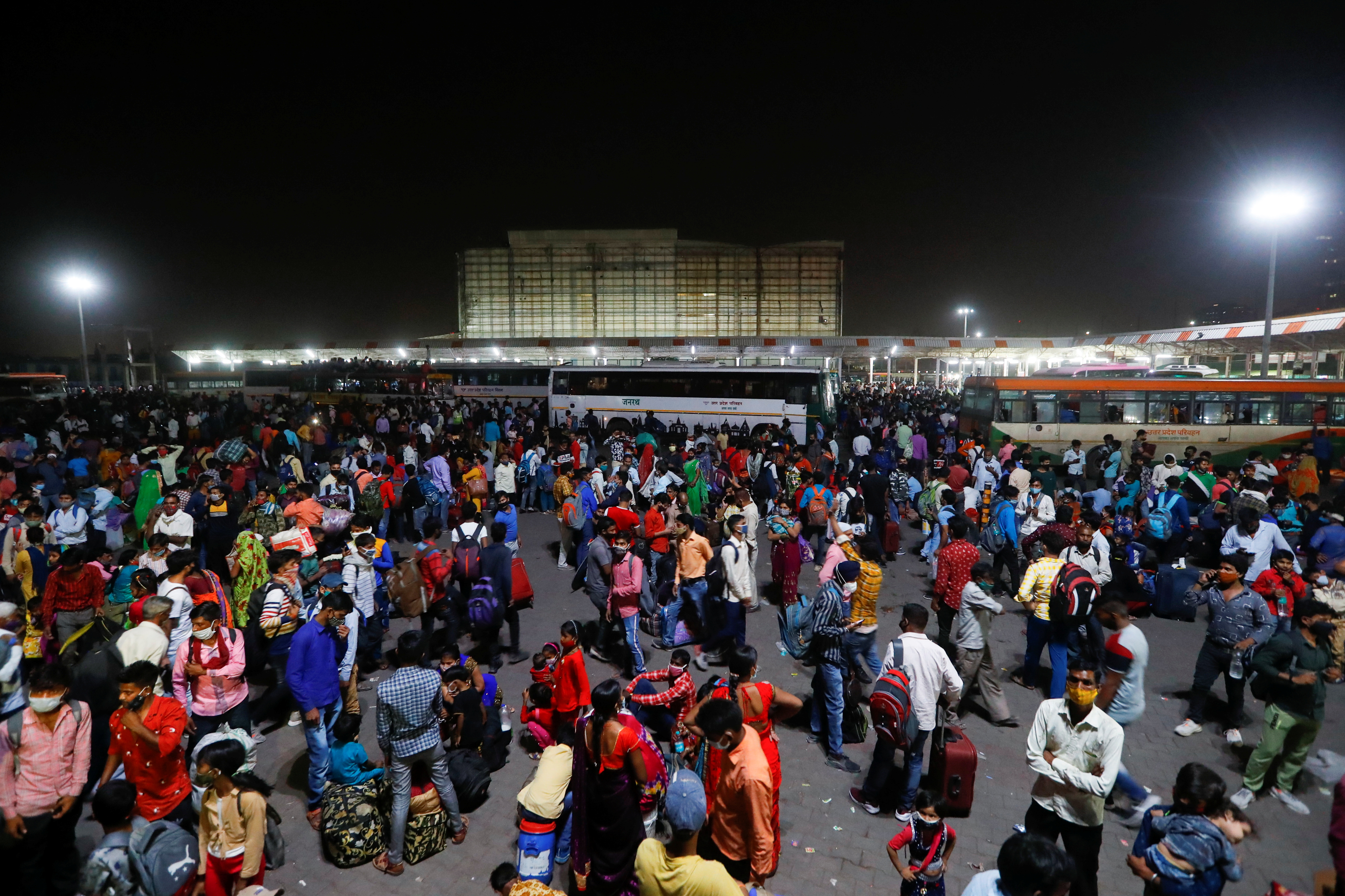 Migrant workers gather at a bus station to board buses to return to their villages after Delhi government ordered a six-day lockdown to limit the spread of the coronavirus disease (COVID-19), in Ghaziabad on the outskirts of New Delhi, India, April 19, 2021. REUTERS/Adnan Abidi