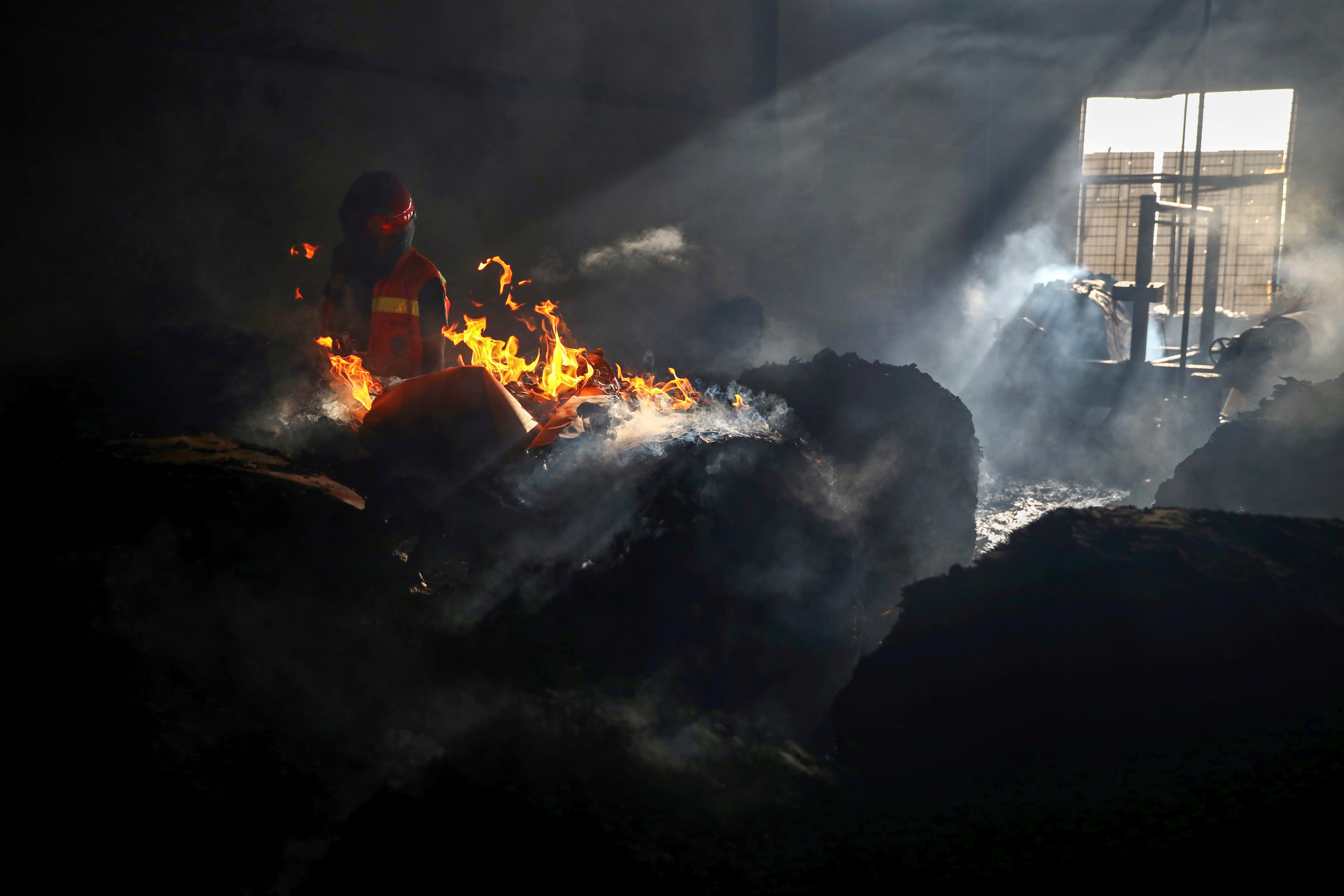 A firefighter tries to extinguish fire inside the building after a fire broke out at a factory named Hashem Foods Ltd. in Rupganj of Narayanganj district, on the outskirts of Dhaka, Bangladesh, July 9, 2021. REUTERS/Mohammad Ponir Hossain