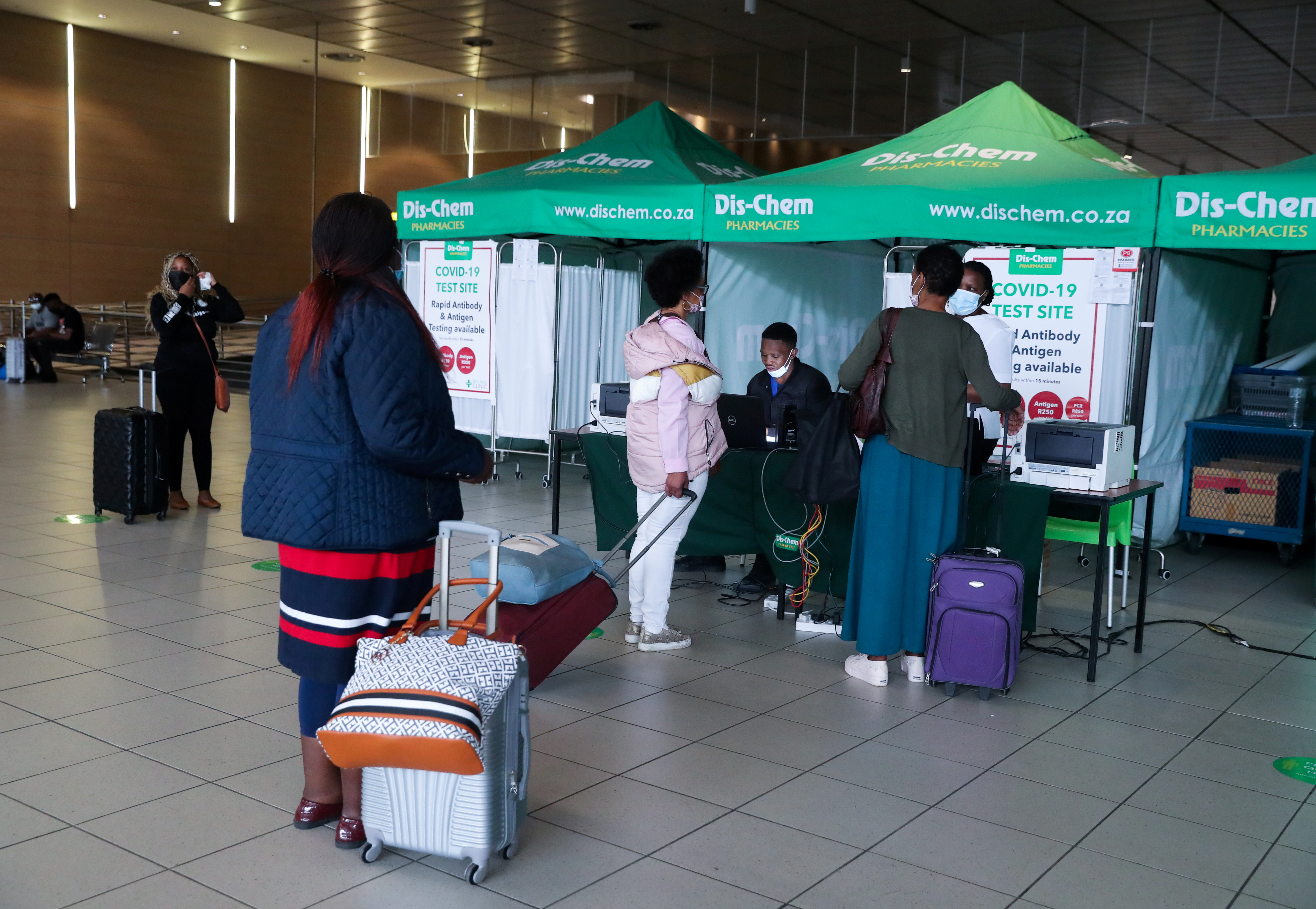 Passengers queue to get a PCR test against COVID-19 before traveling on international flights, at O.R. Tambo International Airport in Johannesburg