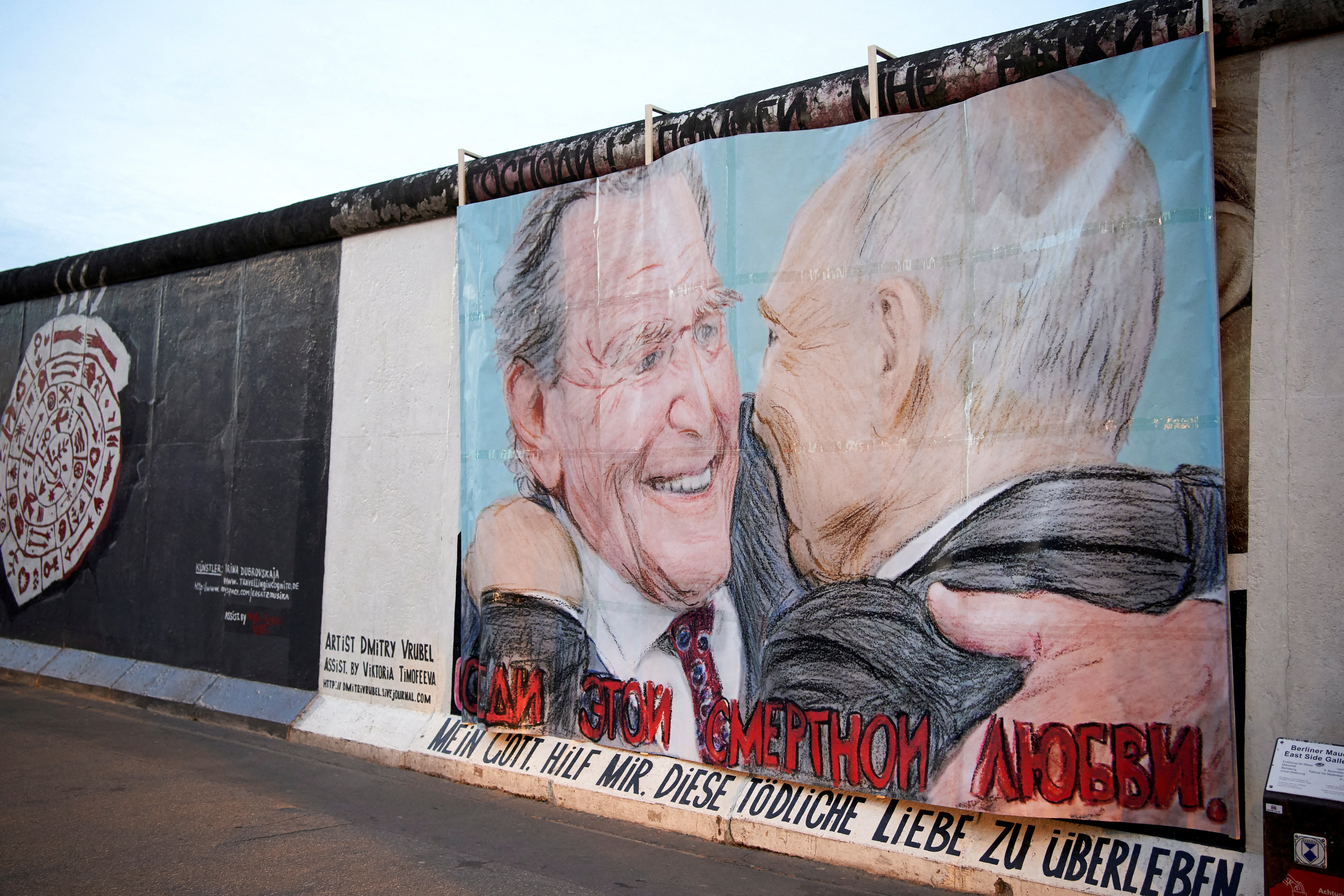 Former German Chancellor Schroeder and Russian President Putin are depicted in a graffiti exchanging a kiss at Berlin's East Side Gallery