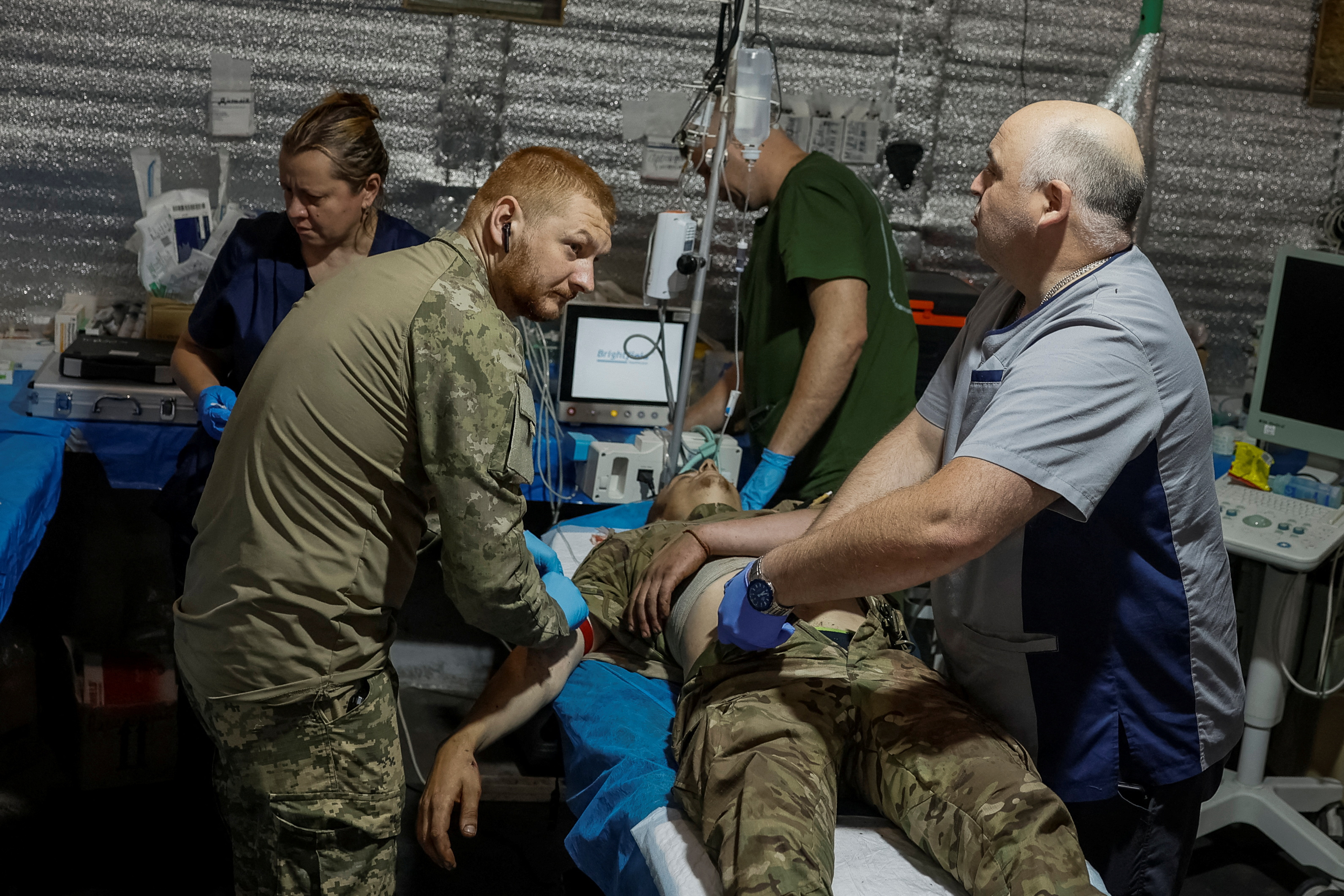 Medics help a wounded Ukrainian serviceman inside a medical stabilisation point near the town of Chasiv Yar, in Donetsk region