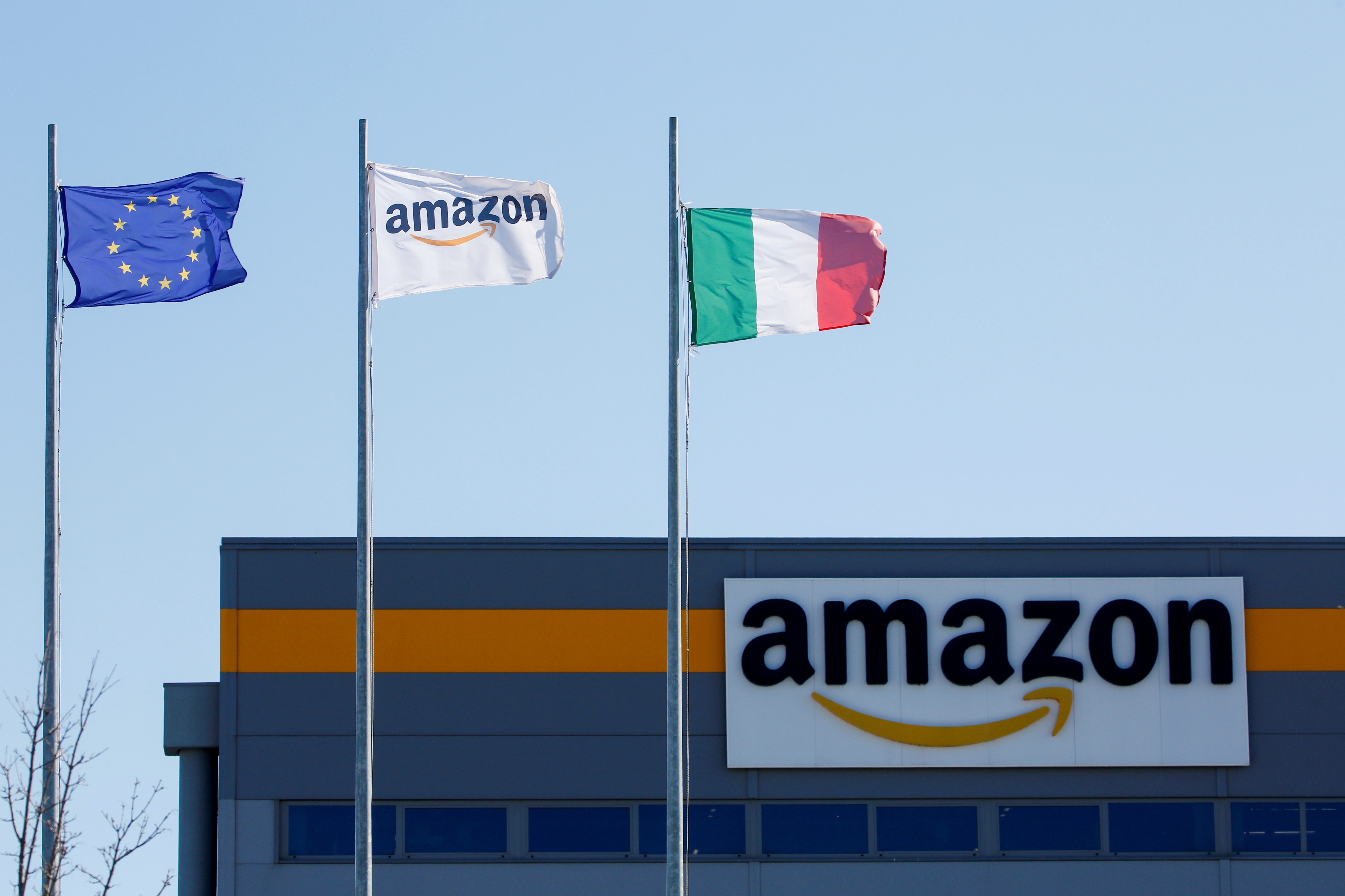 Flags flutter outside a distribution centre, during a strike at Amazon's logistics operations in Italy, in Passo Corese, Italy