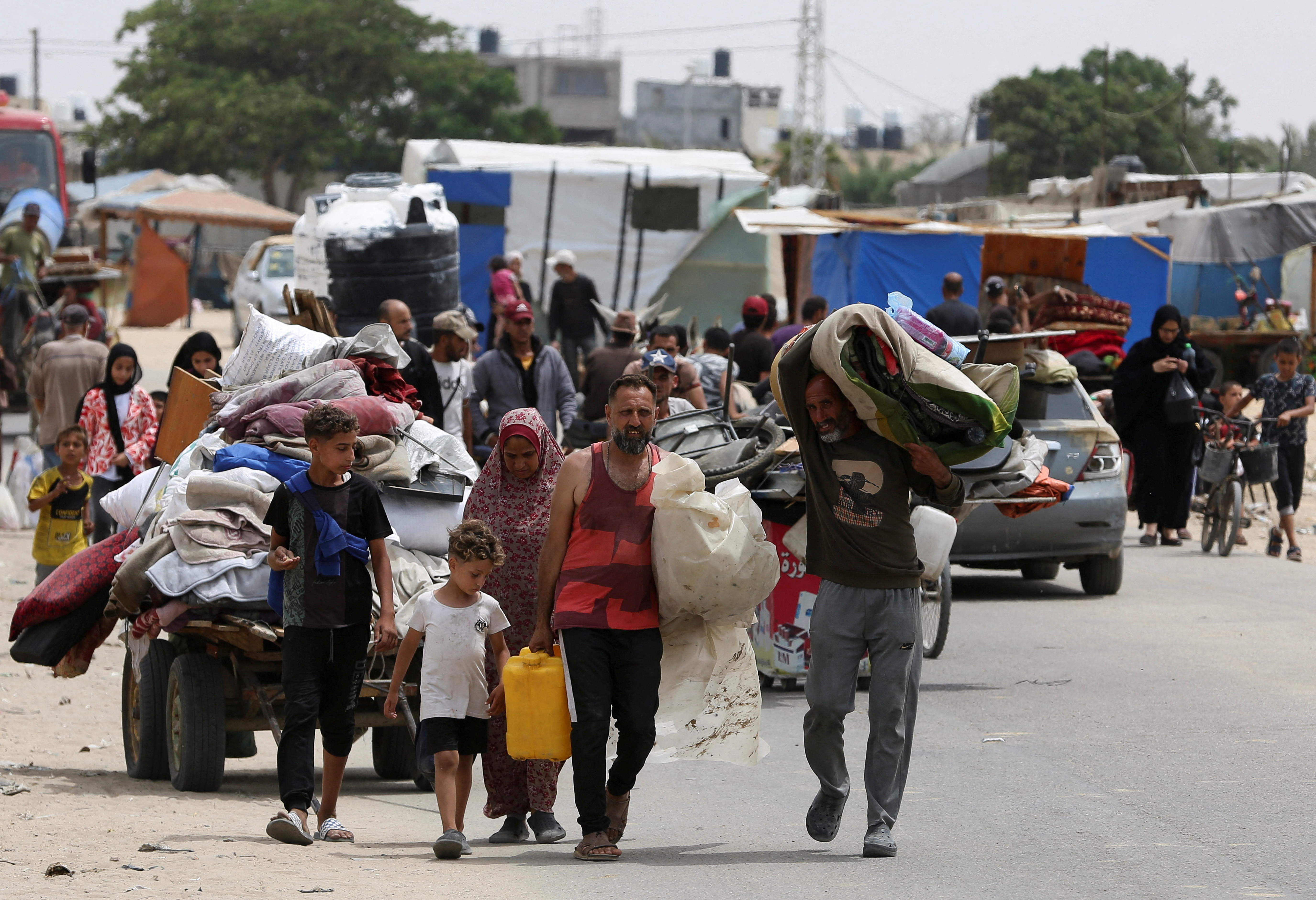 Palestinians travel on foot along with their belongings as they flee Rafah due to an Israeli military operation