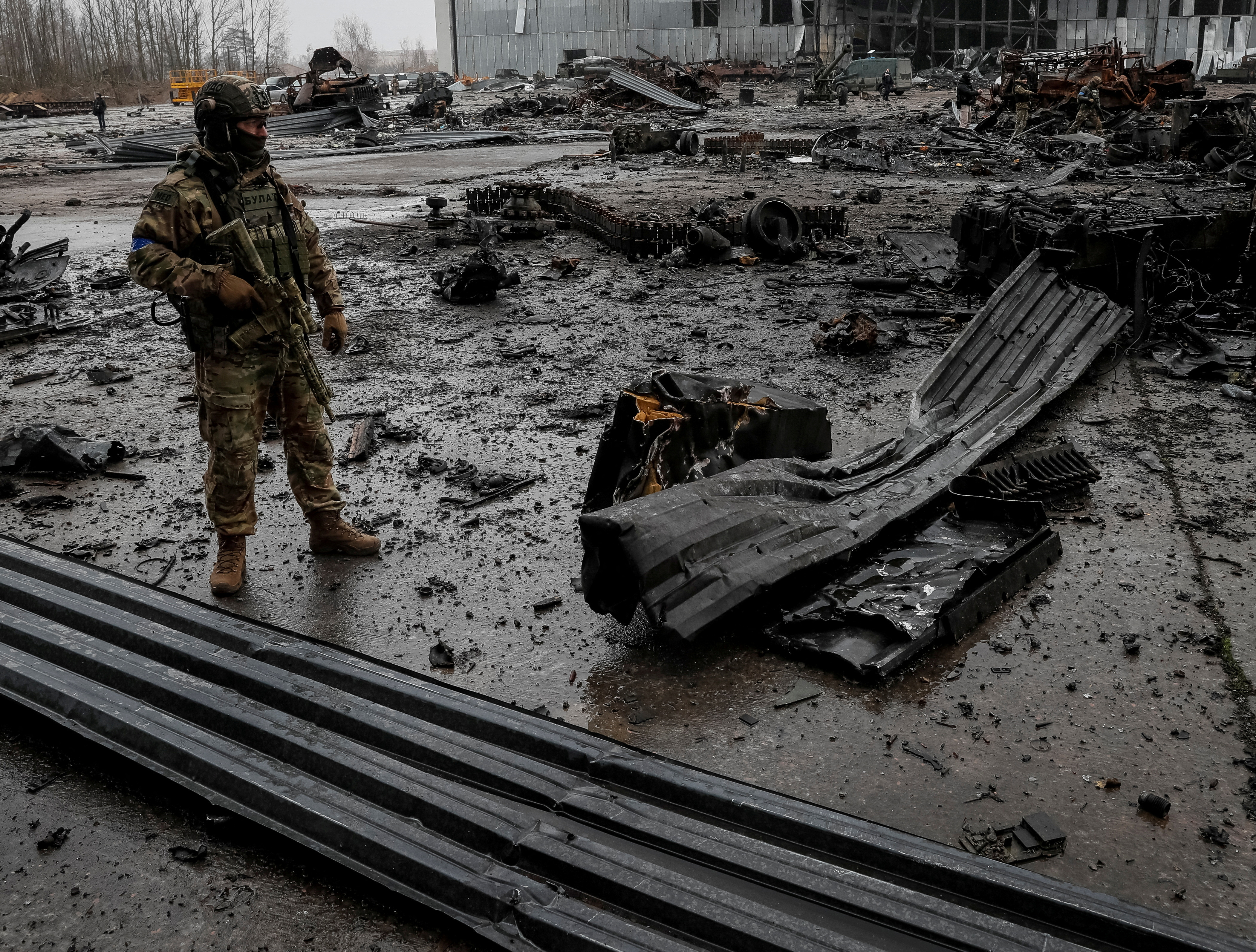 A Ukrainian service member inspects a compound of the Antonov airfield in the settlement of Hostomel