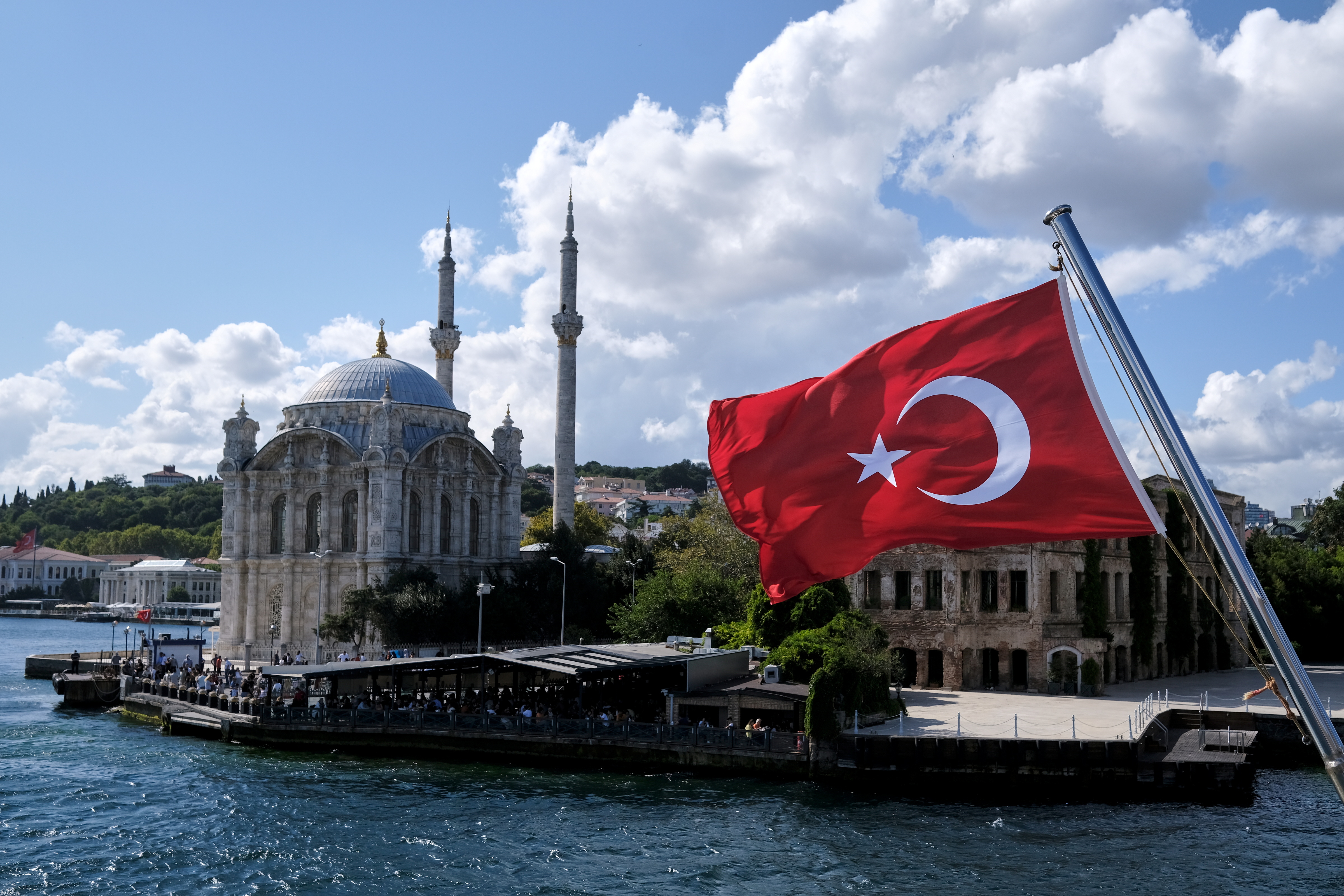 A Turkish flag is pictured on a boat with the Ortakoy Mosque in the background in Istanbul