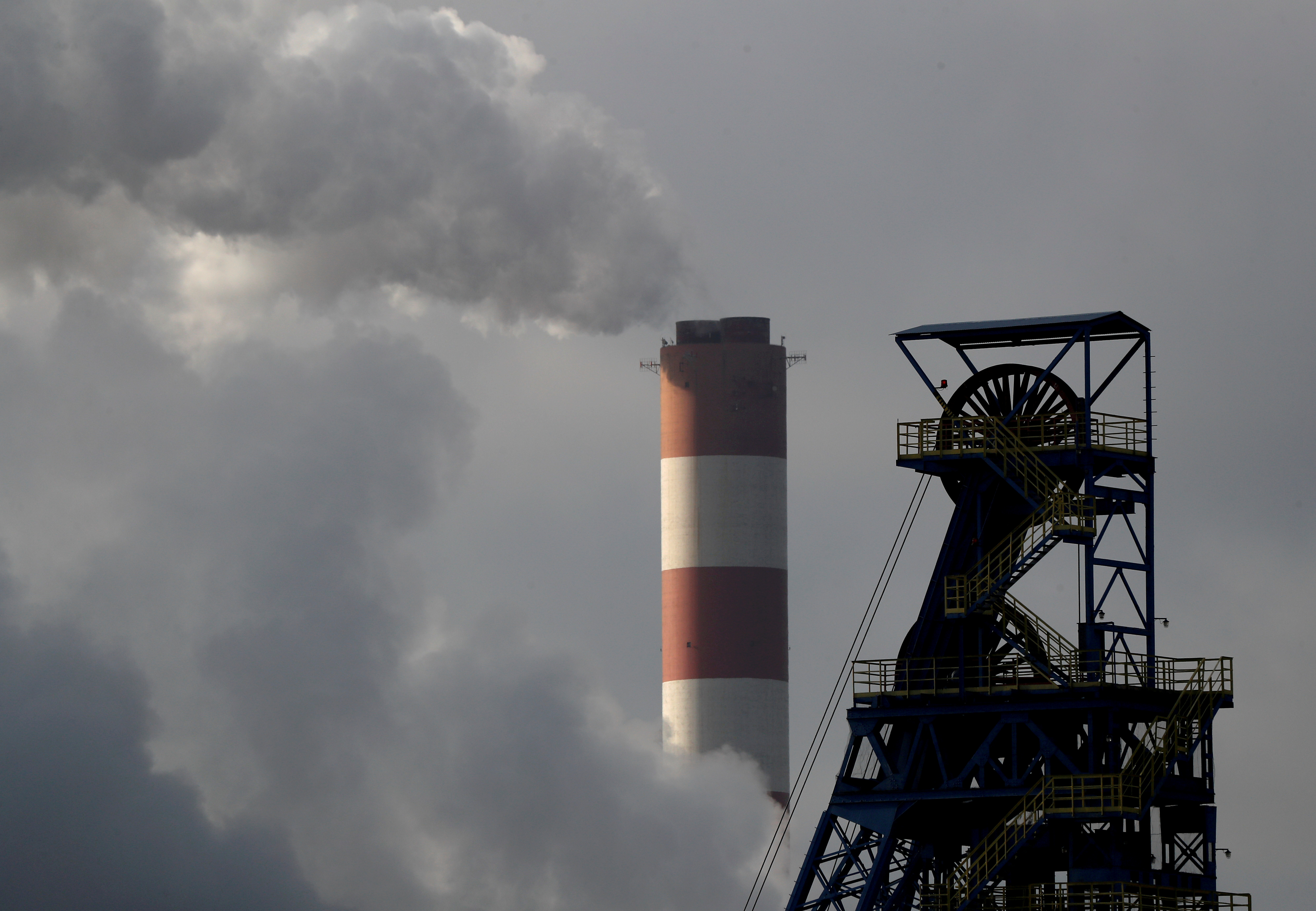 a chimney at Laziska power station is seen behind the Boleslaw Smialy coal mine in Poland