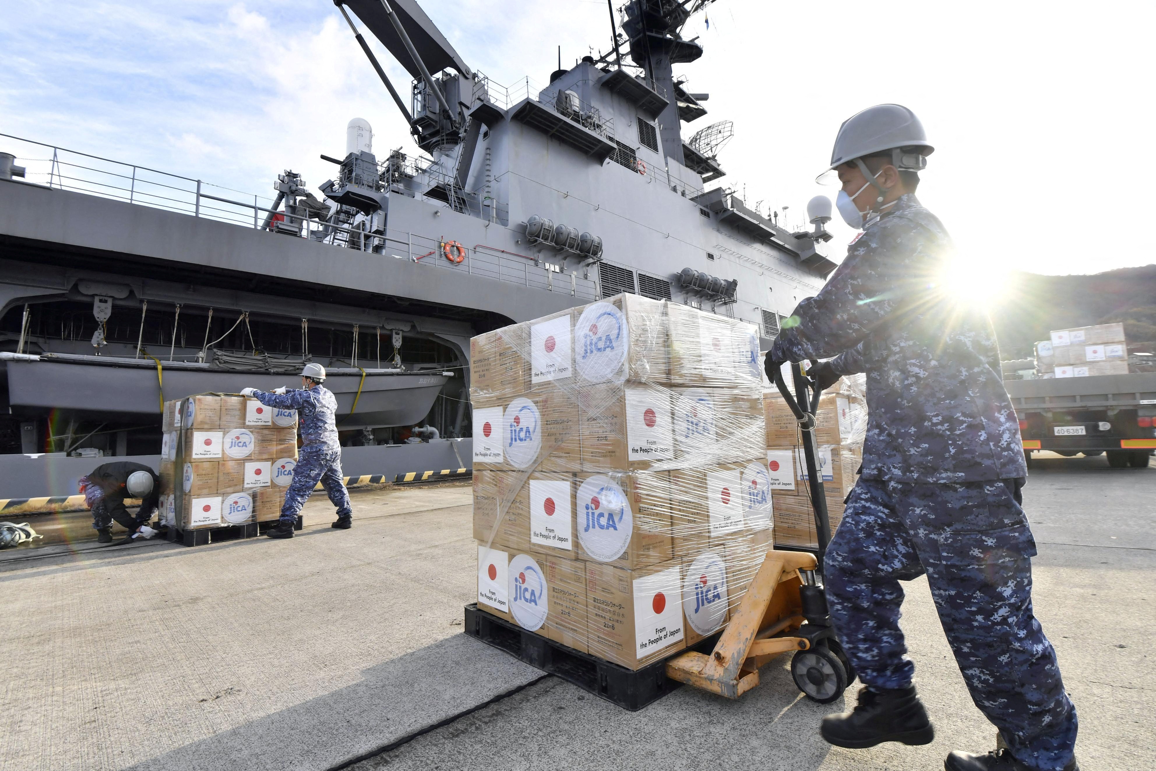 Japan Self-Defense Forces officers load relief supplies to be deployed to Tonga onto transport vessel Osumi in Kure, Japan