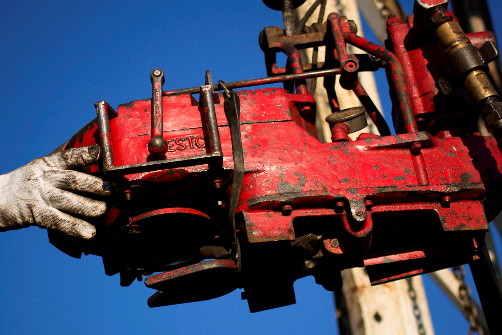 A man works on the rig of an oil drilling pump site in McKenzie County outside of Williston