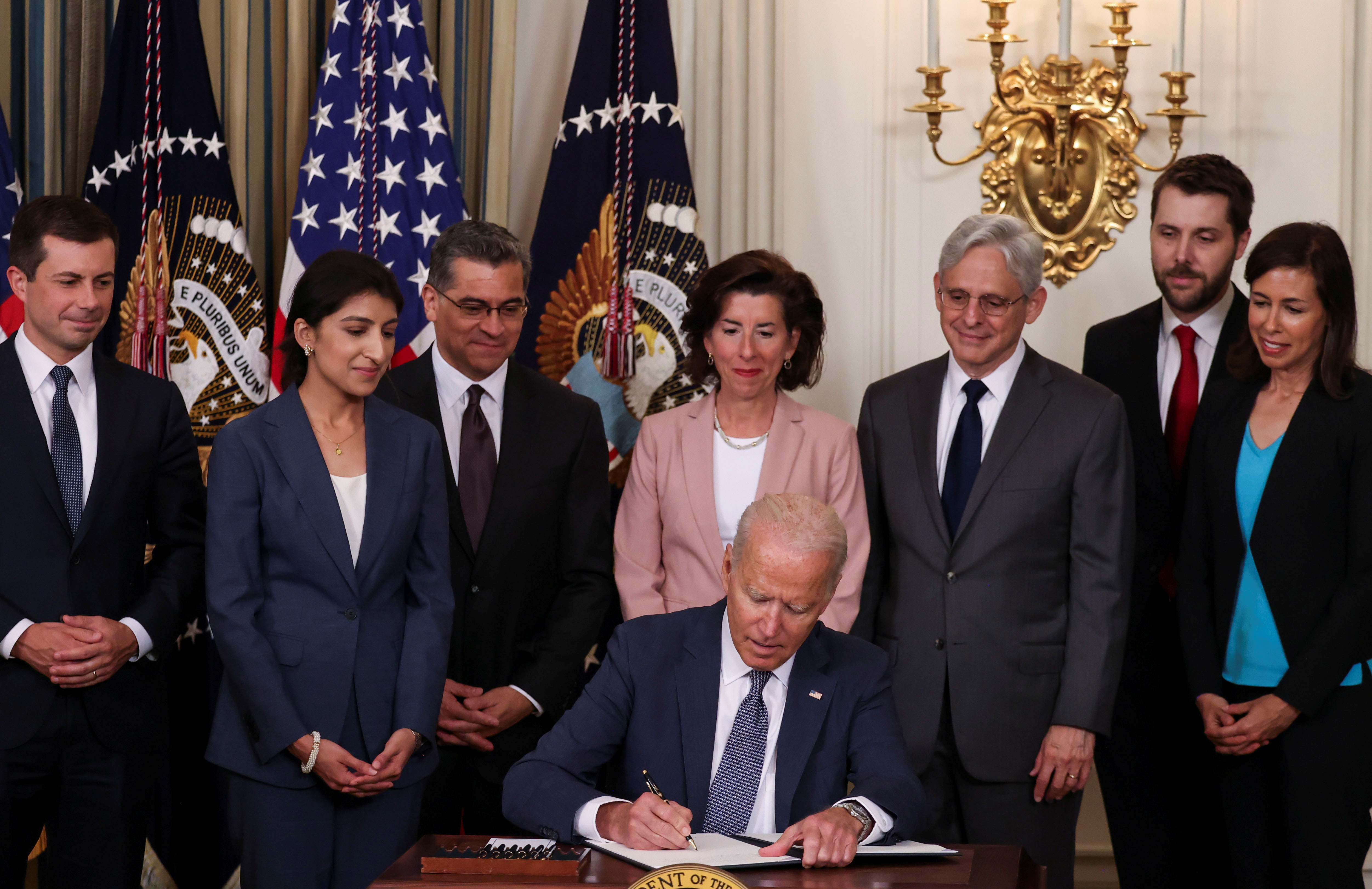  U.S. President Joe Biden signs an executive order on "promoting competition in the American economy" as members of his Cabinet standby during an event in the State Dining Room at the White House in Washington U.S., July 9, 2021. REUTERS/Evelyn Hockstein