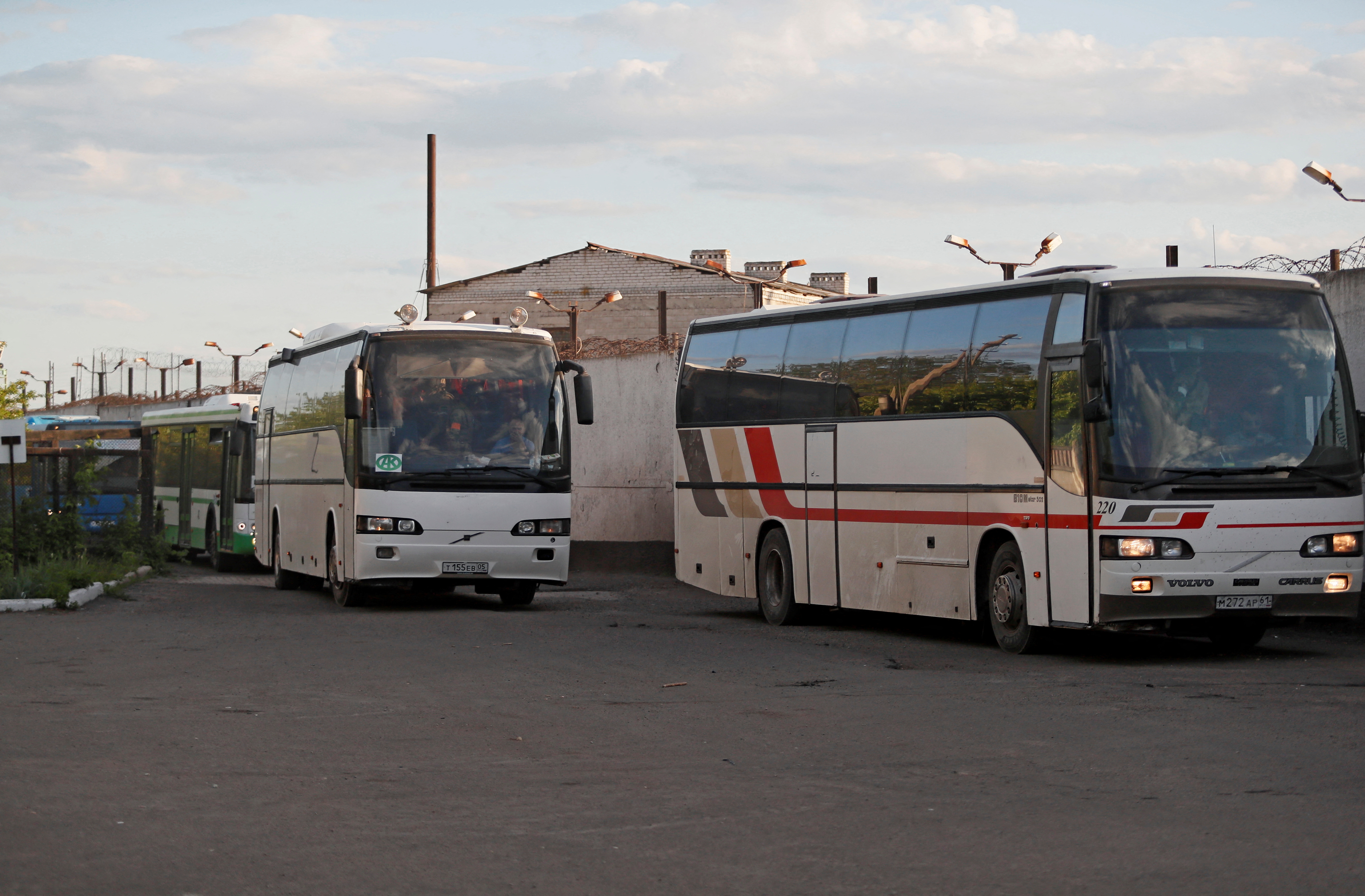 Buses carrying service members of Ukrainian forces who have surrendered after weeks holed up at Azovstal steel works arrive in Olenivka