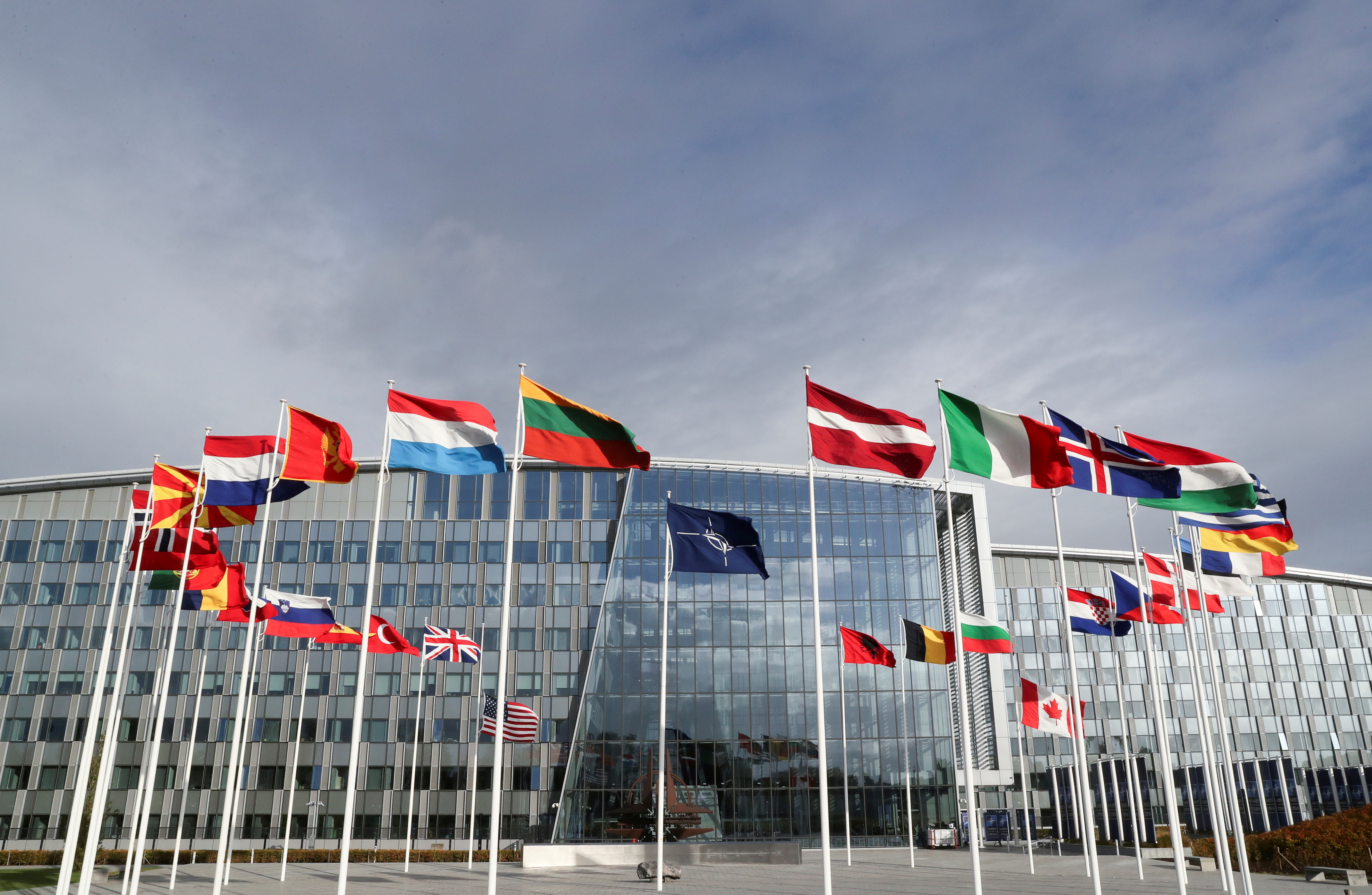 Οι σημαίες κυματίζουν έξω από το αρχηγείο της Συμμαχίας πριν από μια συνάντηση των Υπουργών Άμυνας του ΝΑΤΟ, στις Βρυξέλλες, Βέλγιο, 21 Οκτωβρίου 2021. REUTERS/Pascal Rossignol/File Photo