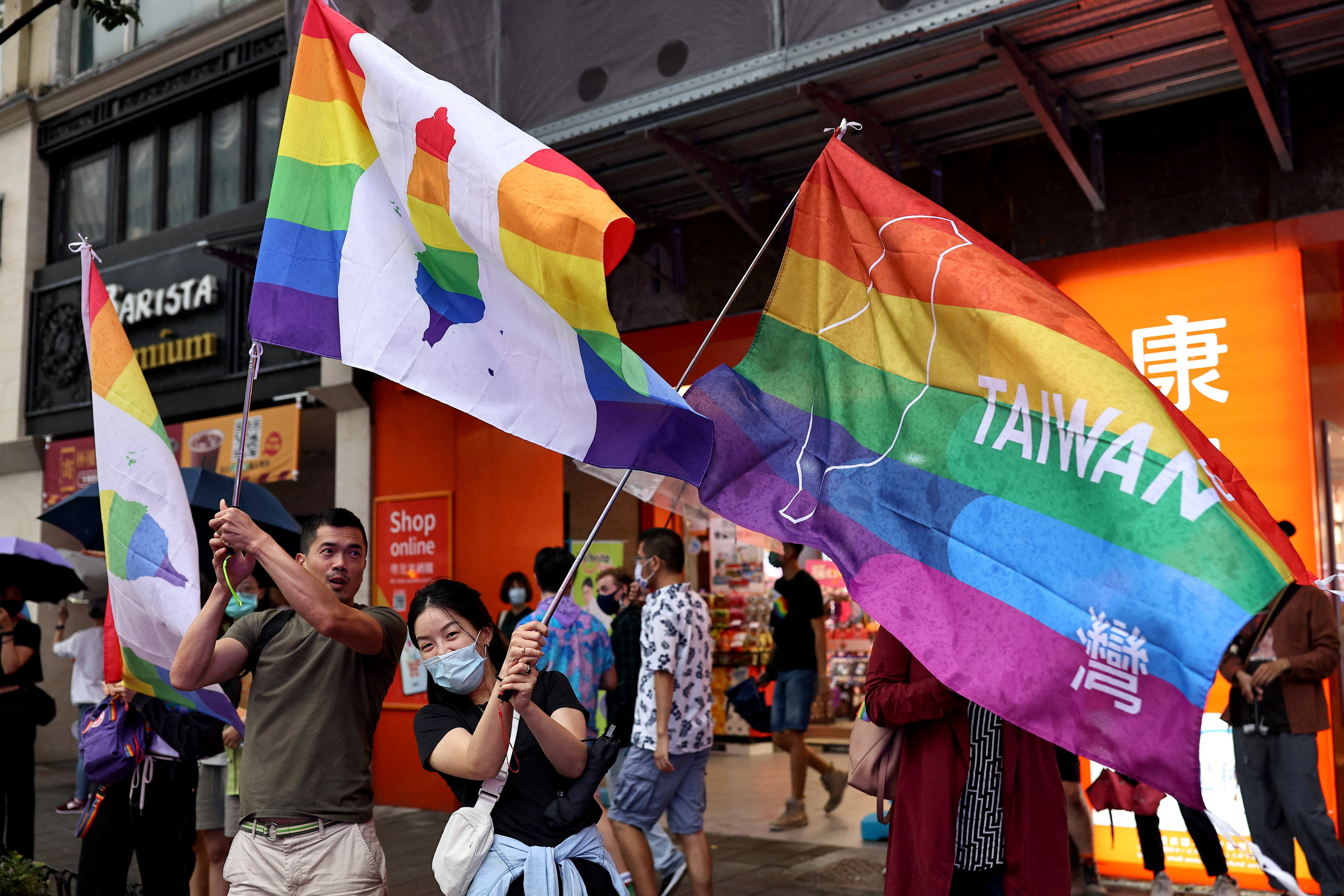 People wave rainbow flags during the annual pride parade in Taipei