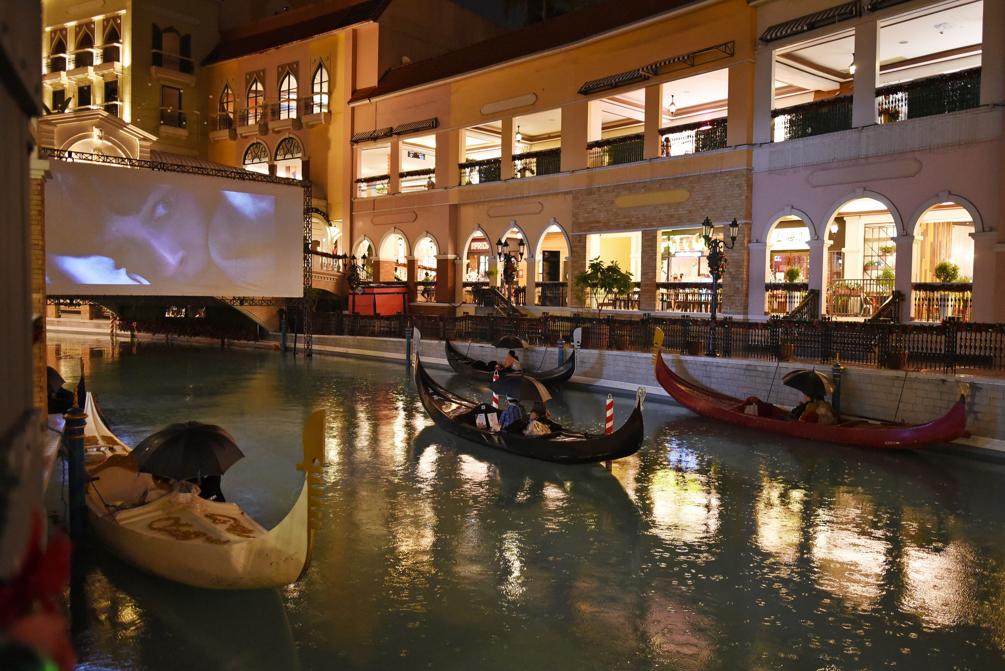 People on gondolas watch a movie while observing social distancing amid coronavirus disease (COVID-19) at a float-in cinema, in Venice Grand Canal Mall, Taguig City, Metro Manila