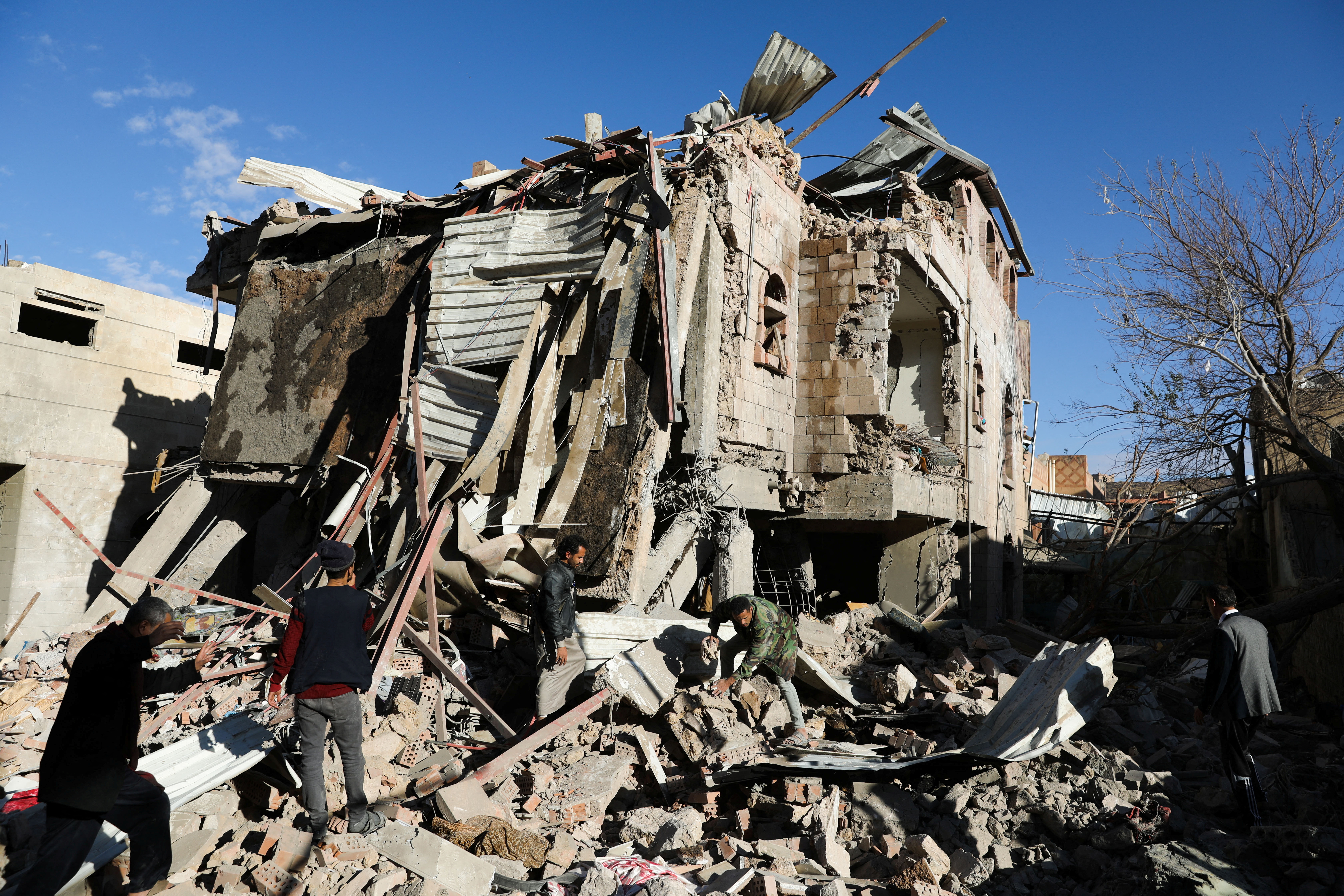 Rescuers remove debris at the site of Saudi-led air strikes in Sanaa