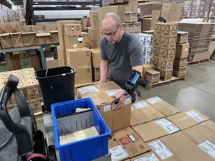 A worker uses an arm-mounted scanner to pack an order at Kem Krest's warehouse in Elkhart