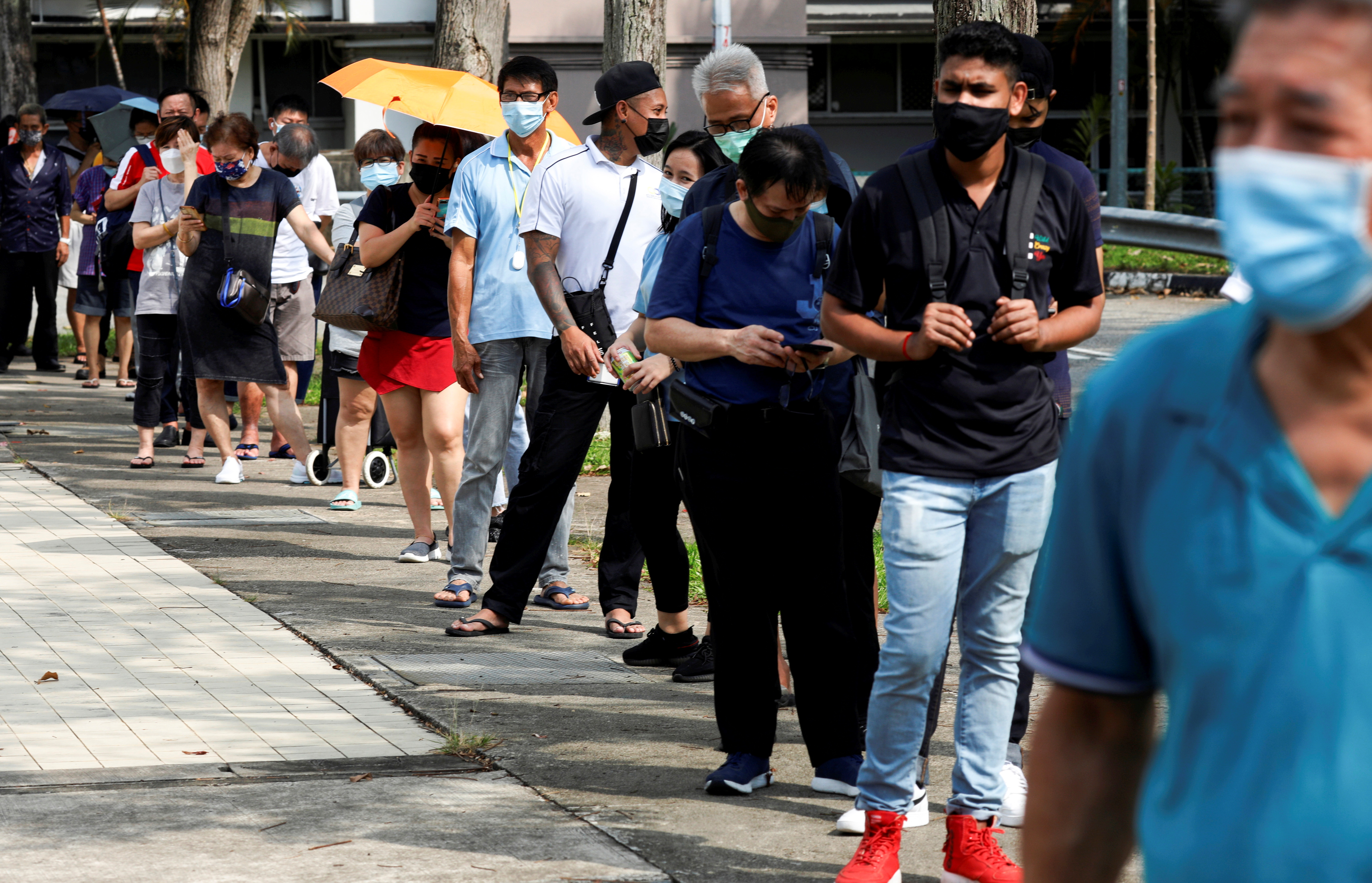People queue up outside a quick test centre to take their coronavirus disease (COVID-19) antigen rapid tests, in Singapore