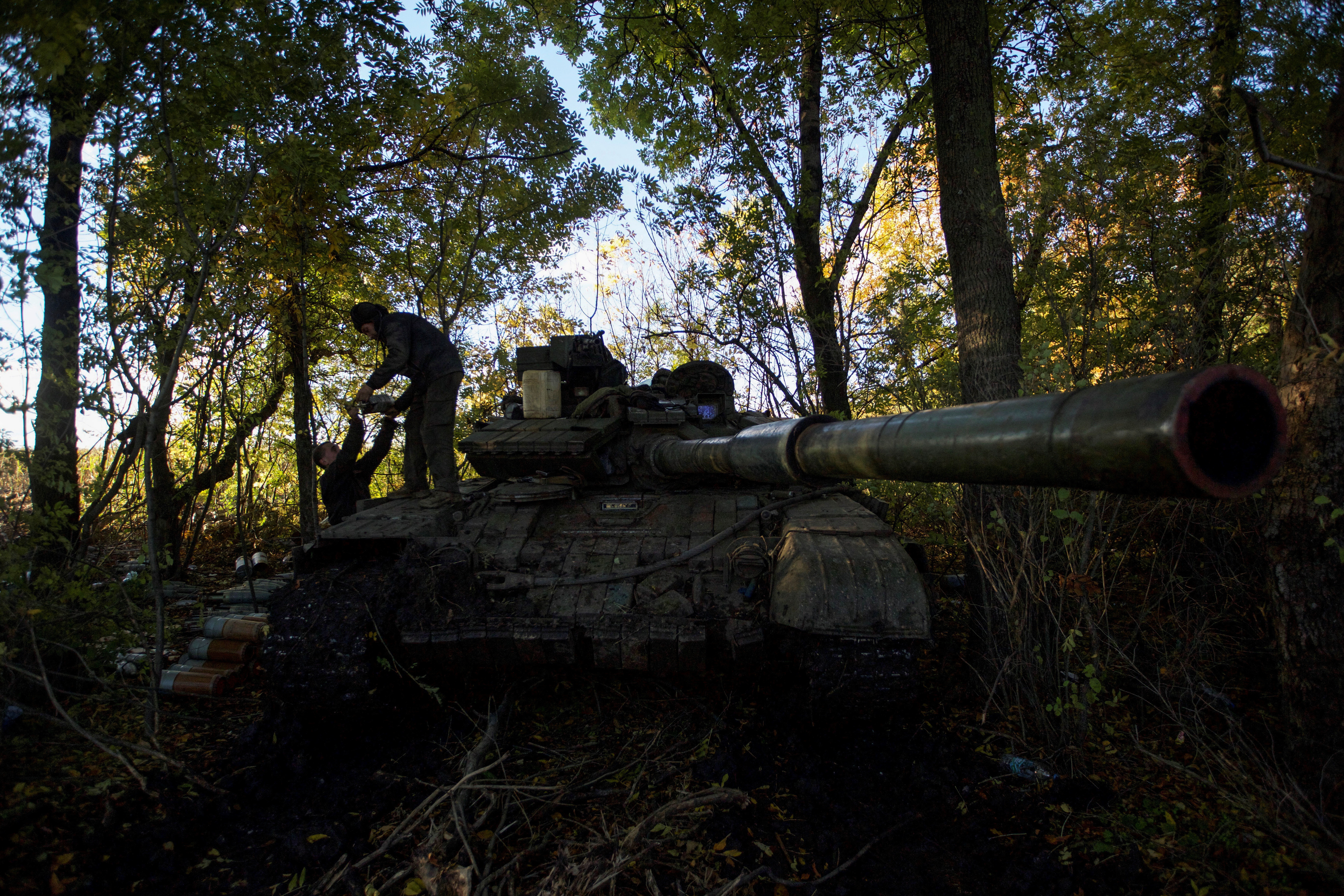Ukrainian service members load shells into a tank at a position near a frontline outside the town of Bakhmut