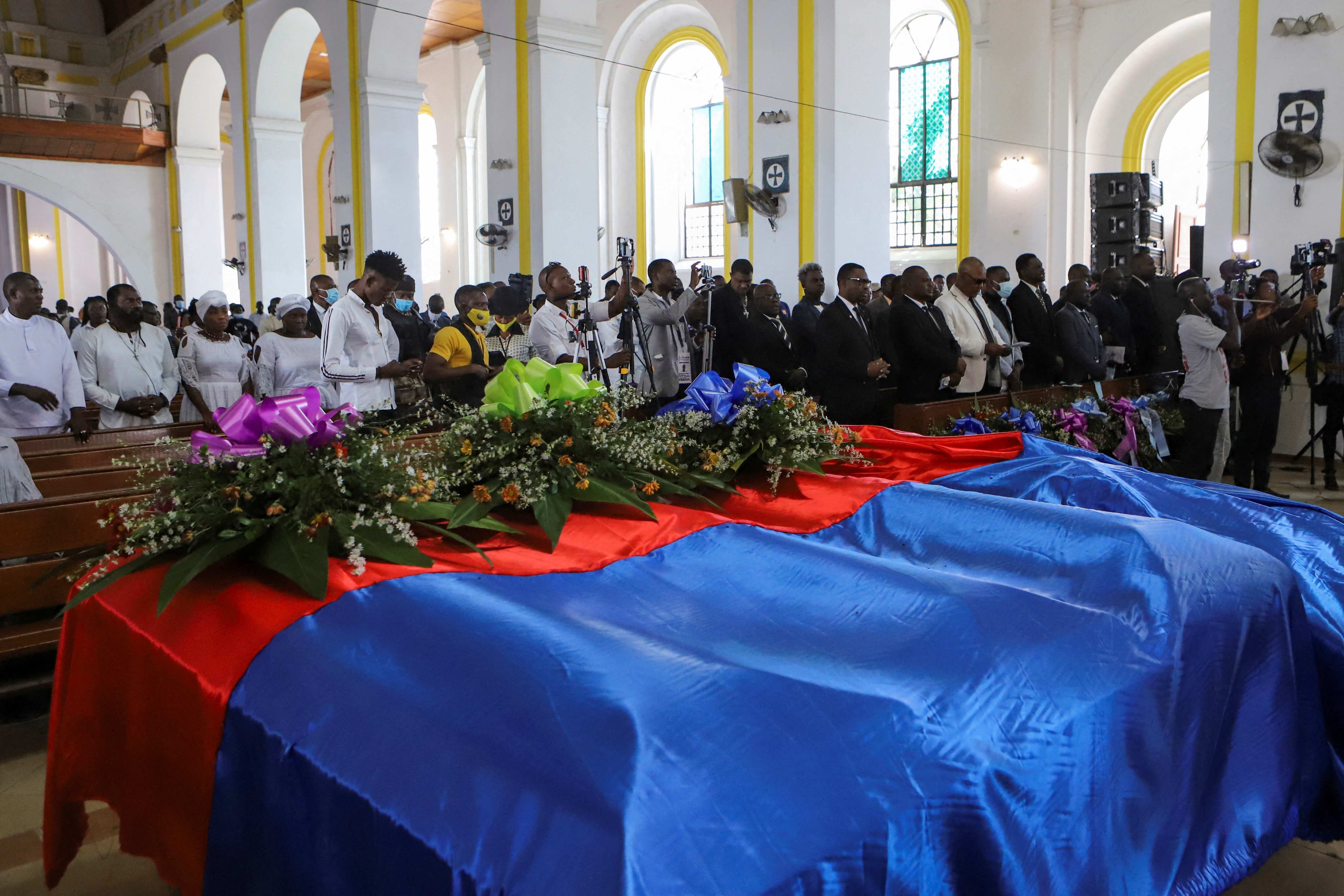 Caskets draped in a Haitian flag are displayed at a mass funeral for victims of a fuel truck explosion, in Cap Haitien, Haiti December 21, 2021. REUTERS/Ralph Tedy Erol