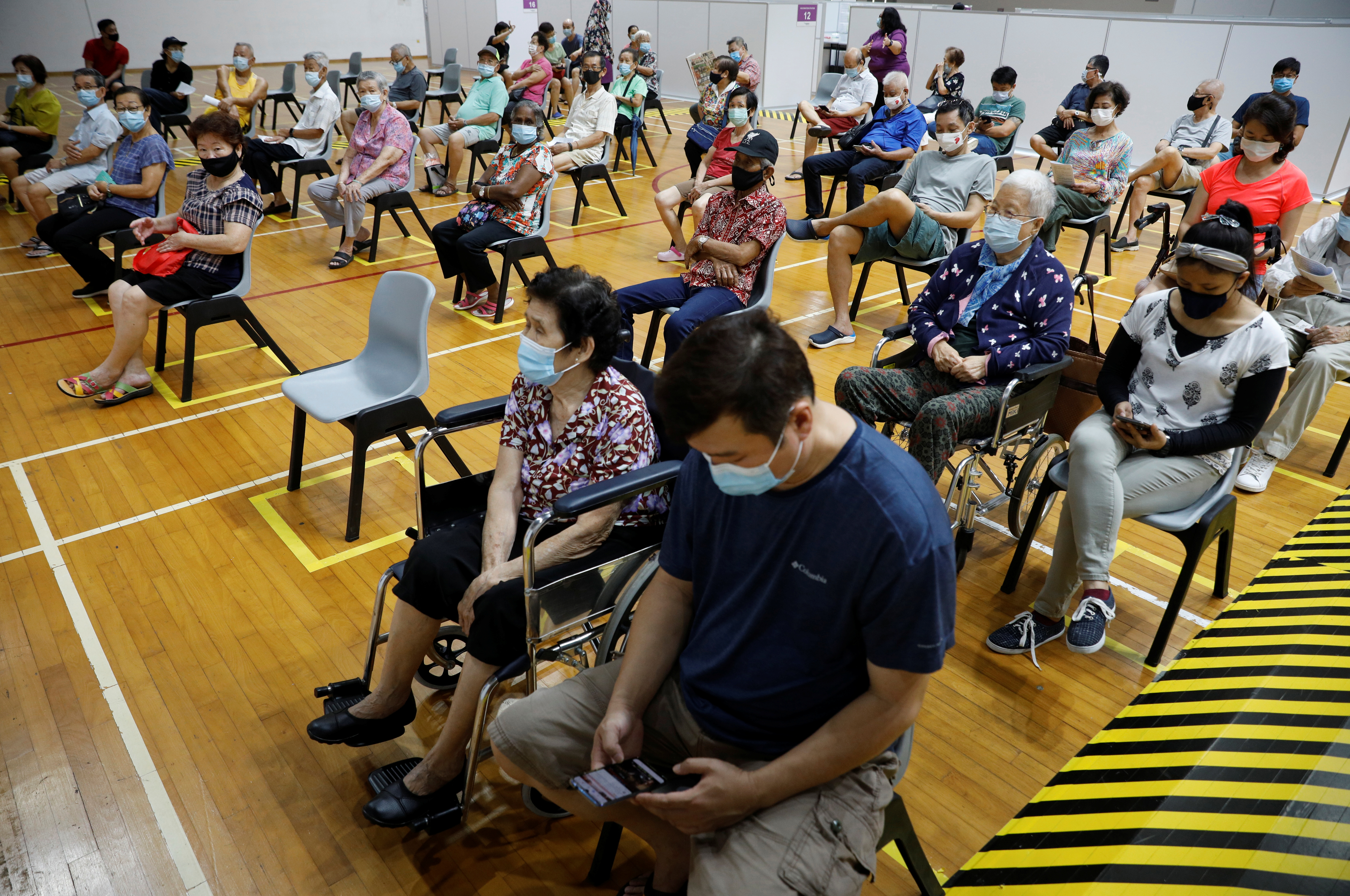 People wait at an observation area after their vaccination at a coronavirus disease (COVID-19) vaccination center in Singapore March 8, 2021. REUTERS/Edgar Su