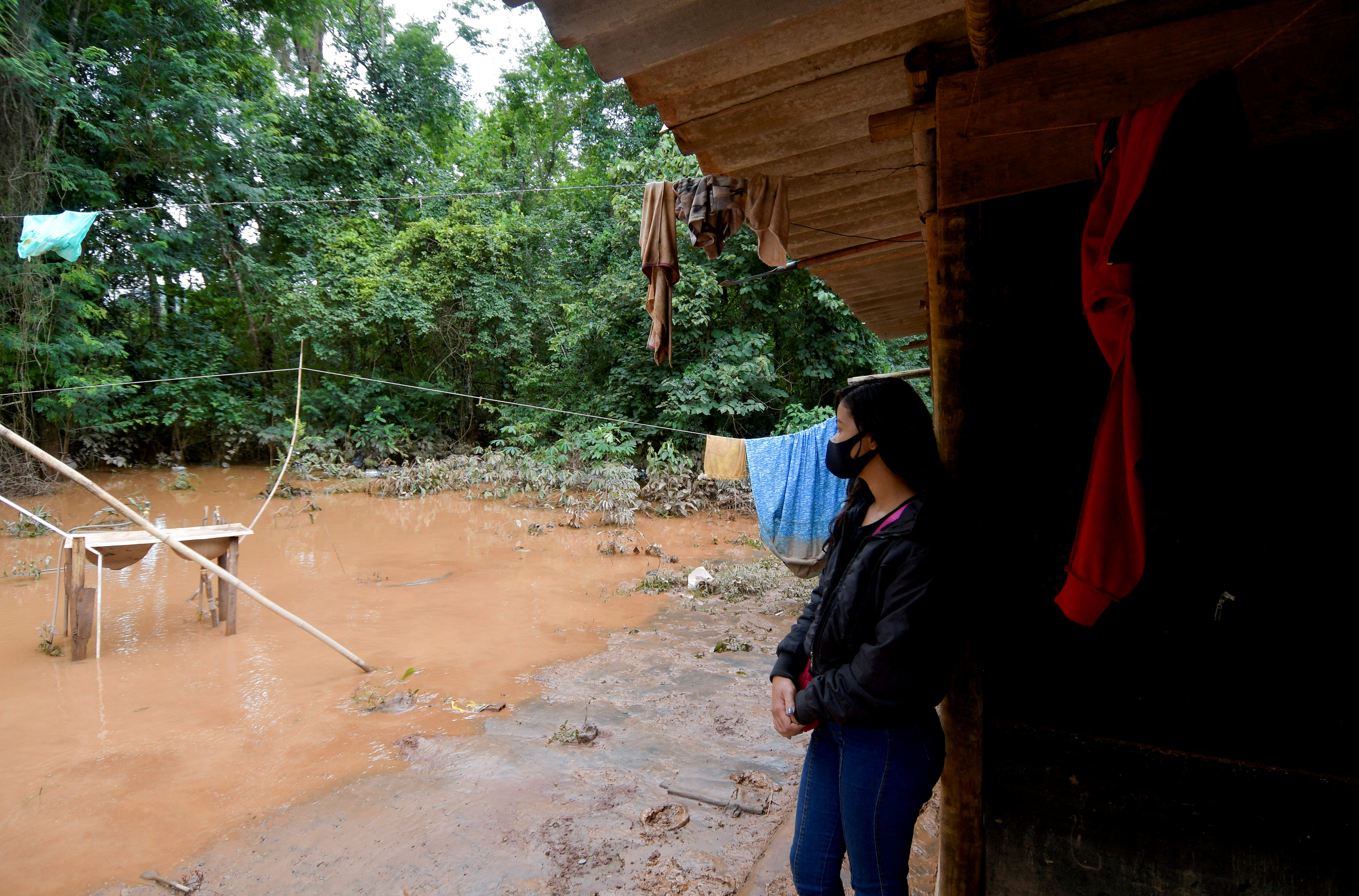 An indigenous woman of the Pataxo ethnicity observes flooding in Nao Xoha village after pouring rains, in Sao Joaquim de Bicas, in Minas Gerais state, Brazil January 12, 2022. REUTERS/Washington Alves