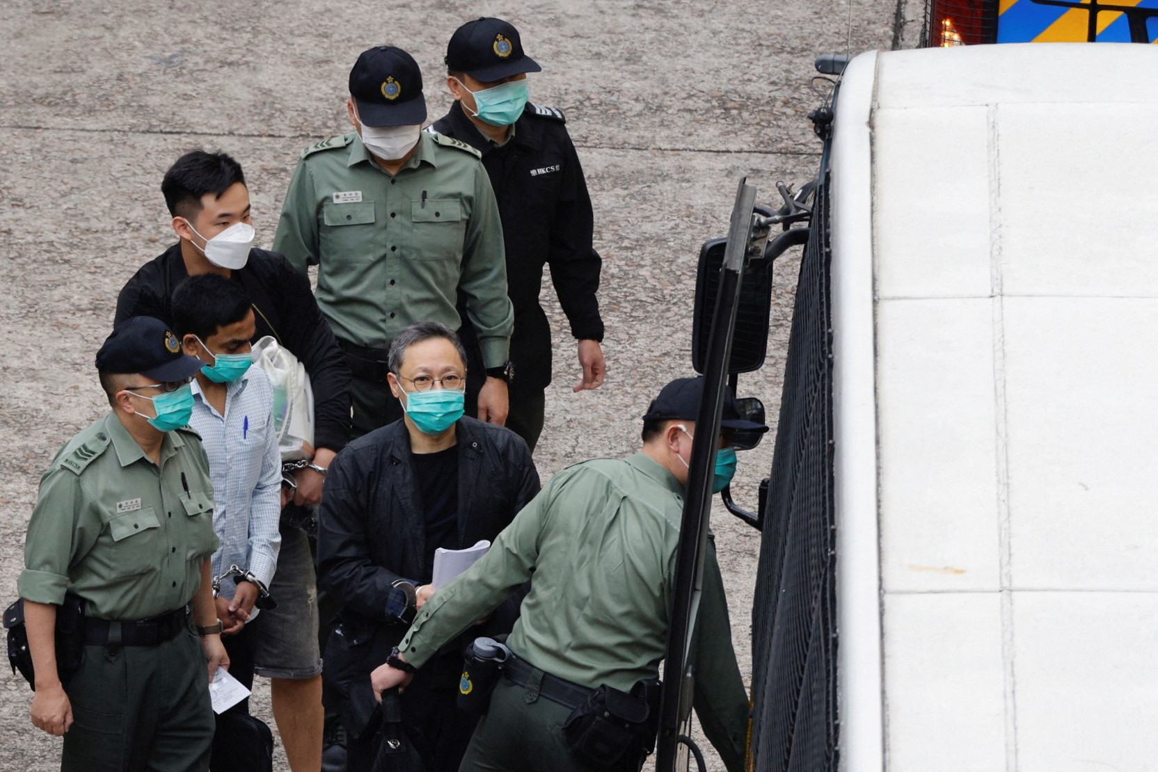 Pro-democracy activist Benny Tai walks to a prison van to head to court over the national security law charge, in the early morning, in Hong Kong