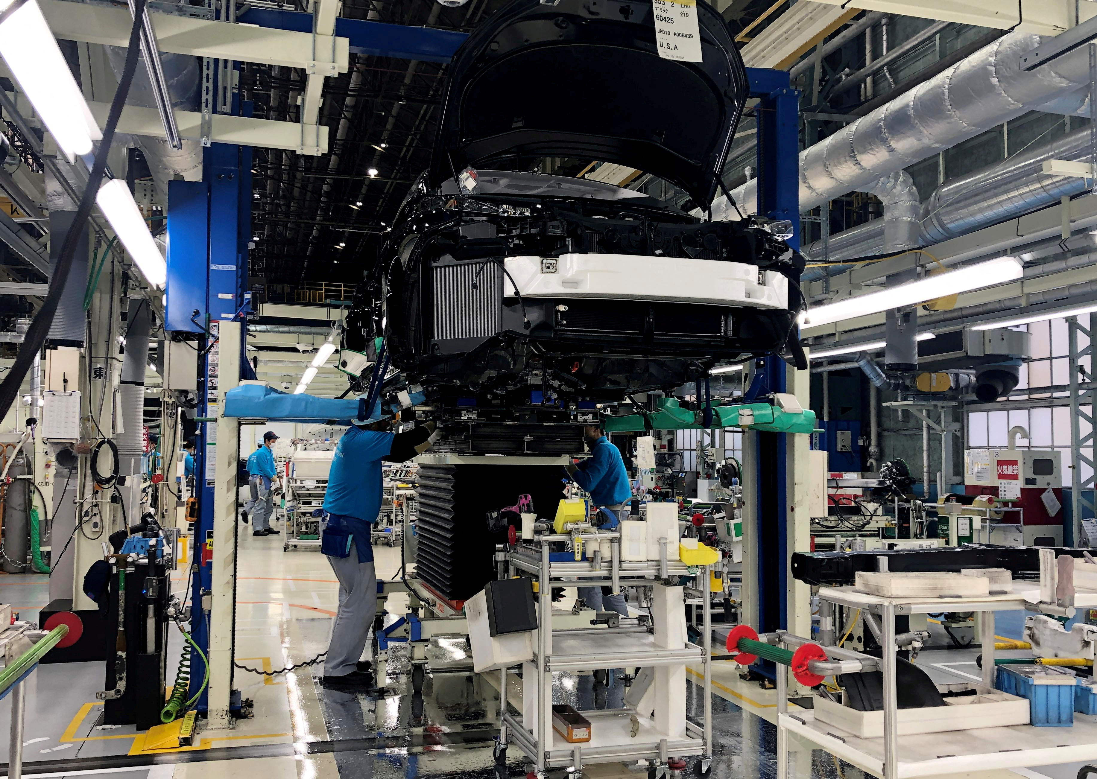 Workers install the fuel cell power system in a Toyota Mirai at a Toyota Motor Corp. factory in Toyota
