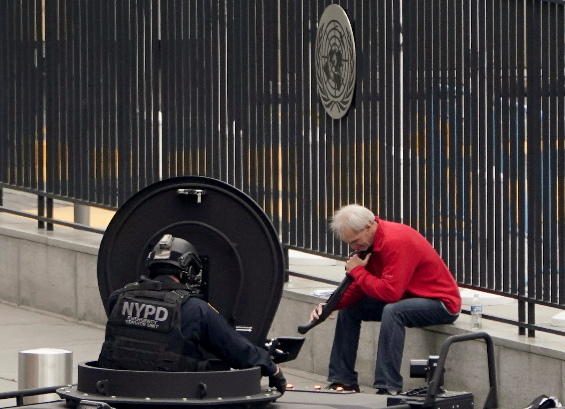 An armed man speaks with member of the NYPD outside the United Nations Headquarters in New York City