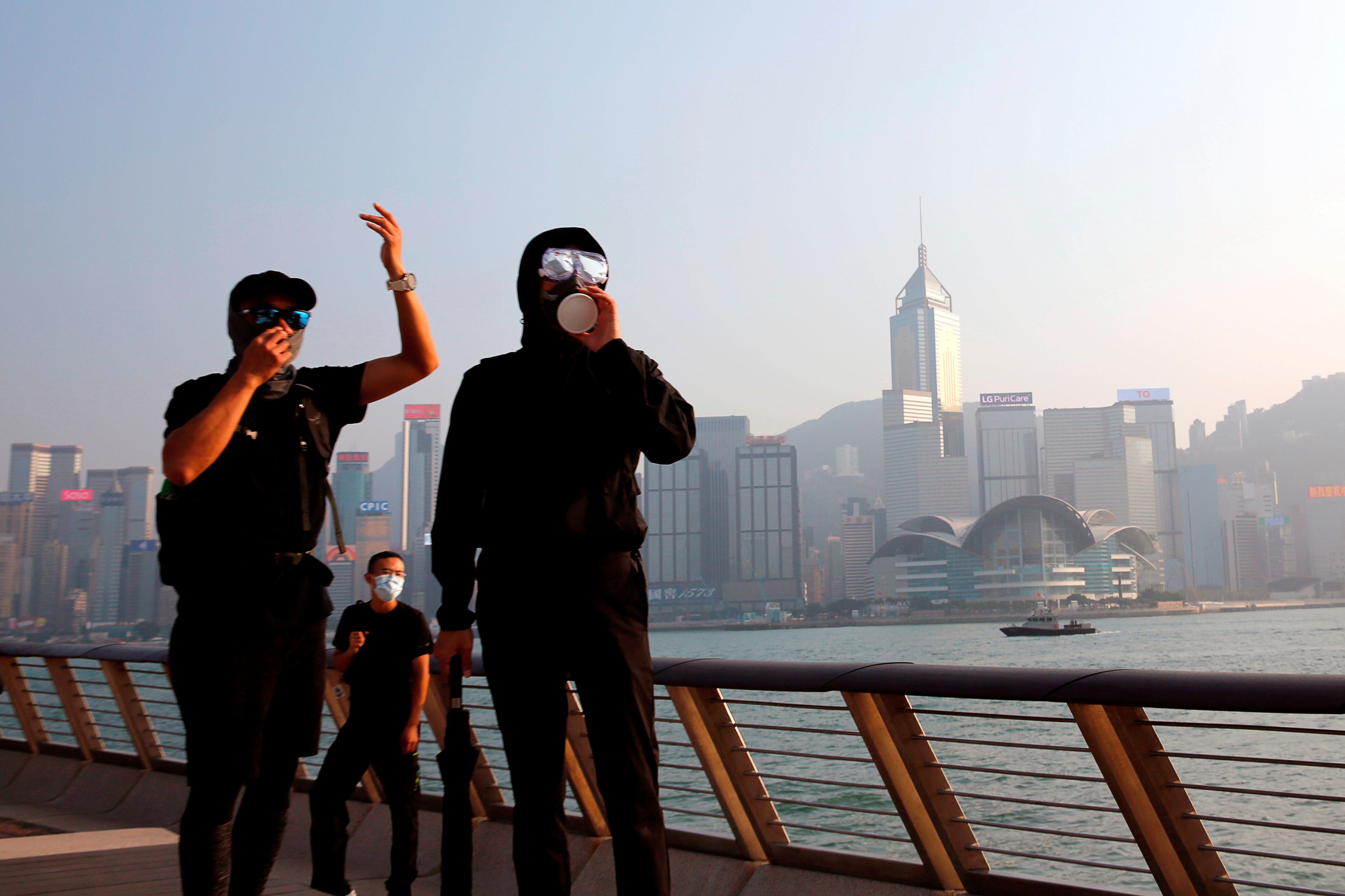 Anti-government protesters react in front of skyline building at Tsim Sha Tsui is in Hong Kong, China October 27, 2019. REUTERS/Tyrone Siu/File Photo