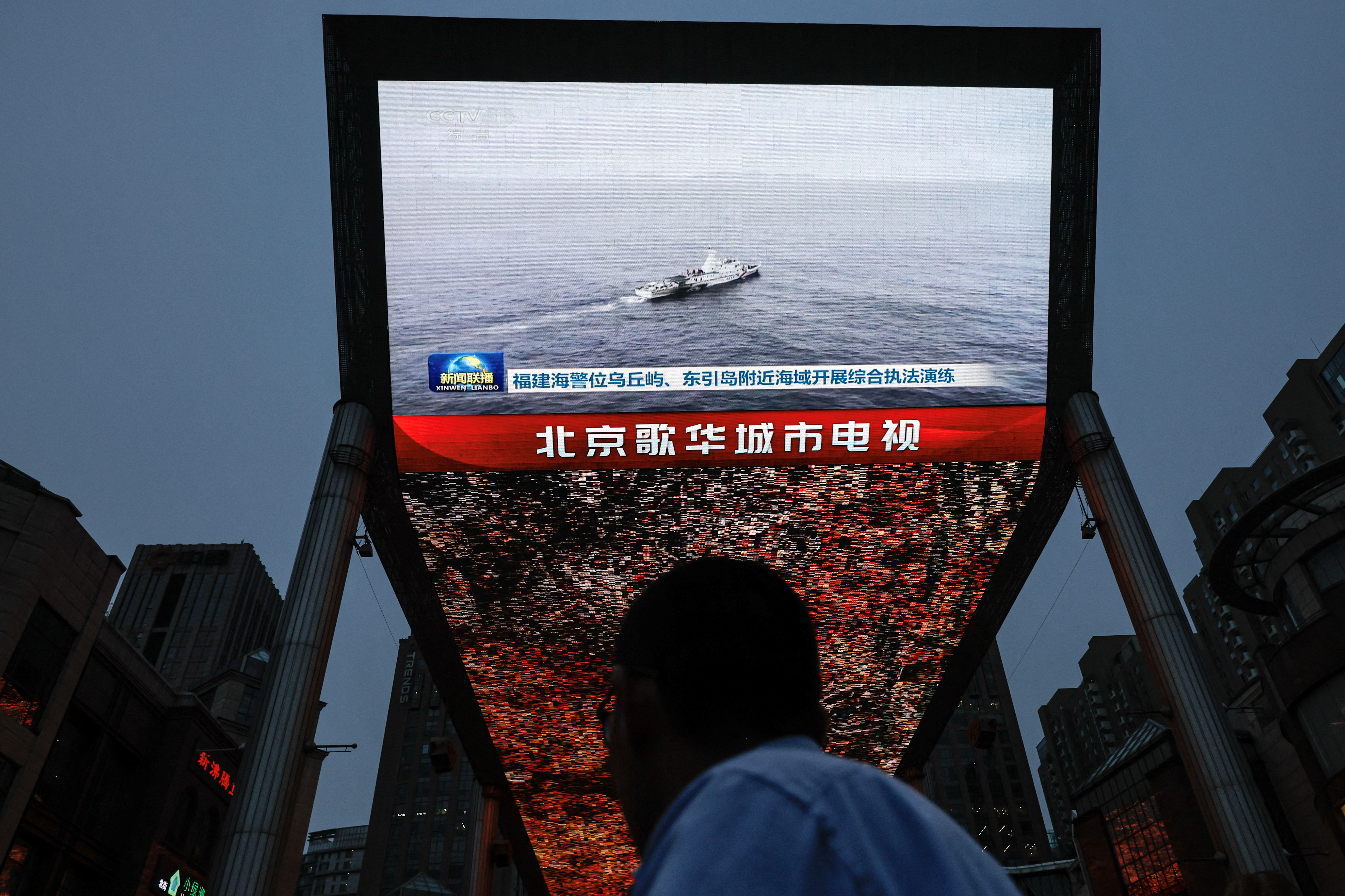 Screen shows news footage of military drills conducted in areas around the island of Taiwan by the Eastern Theatre Command of the Chinese People's Liberation Army (PLA), in Beijing