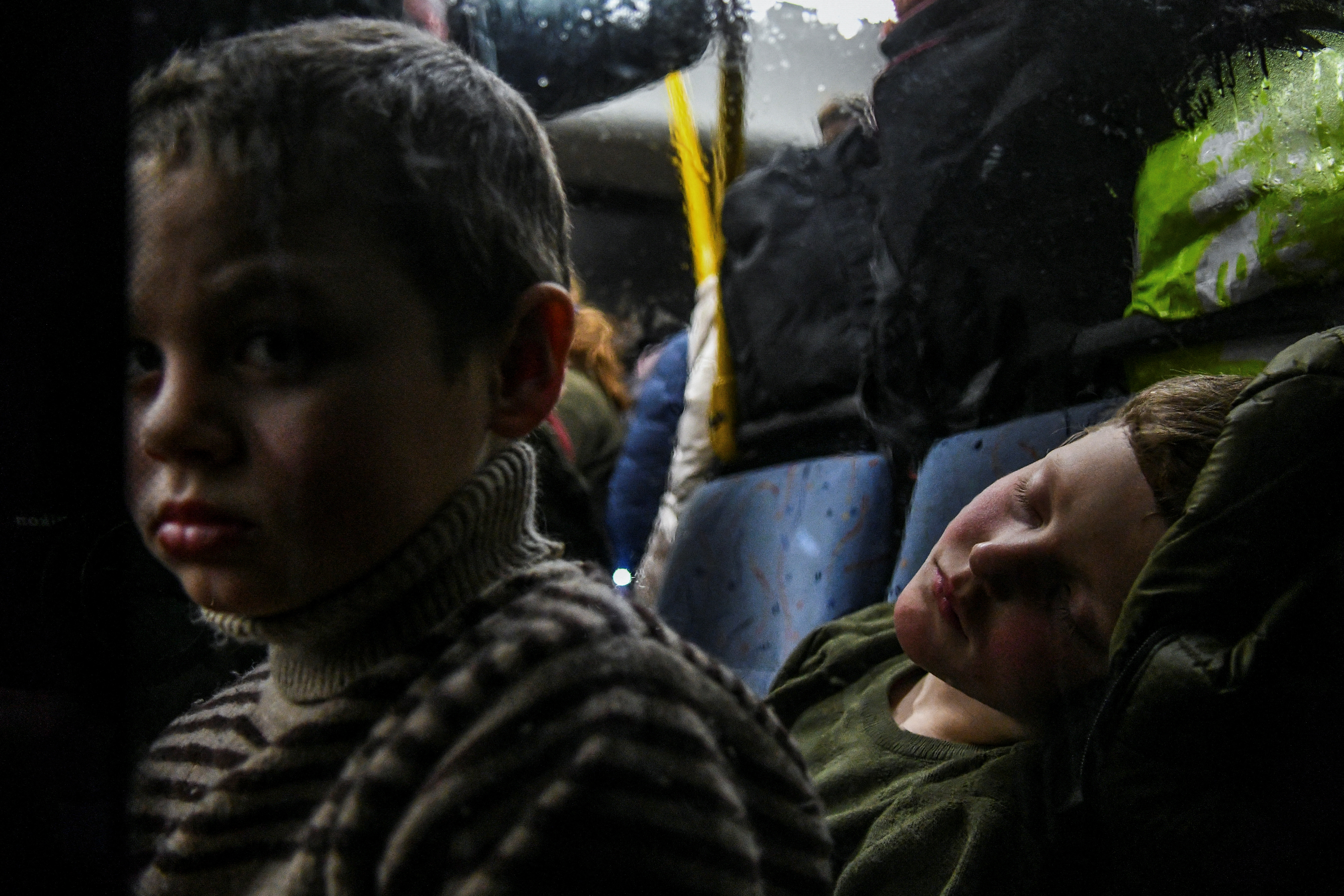 Children rest inside an evacuee bus after they fled from Mariupol to Zaporizhzhia