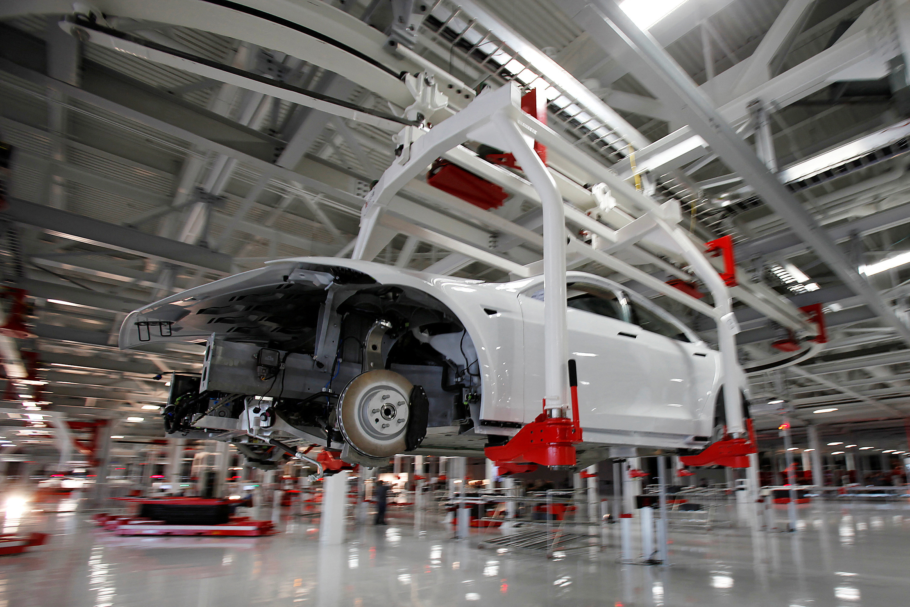 The body of  a Tesla Model S is transported by an automated crane at the Tesla factory in Fremont