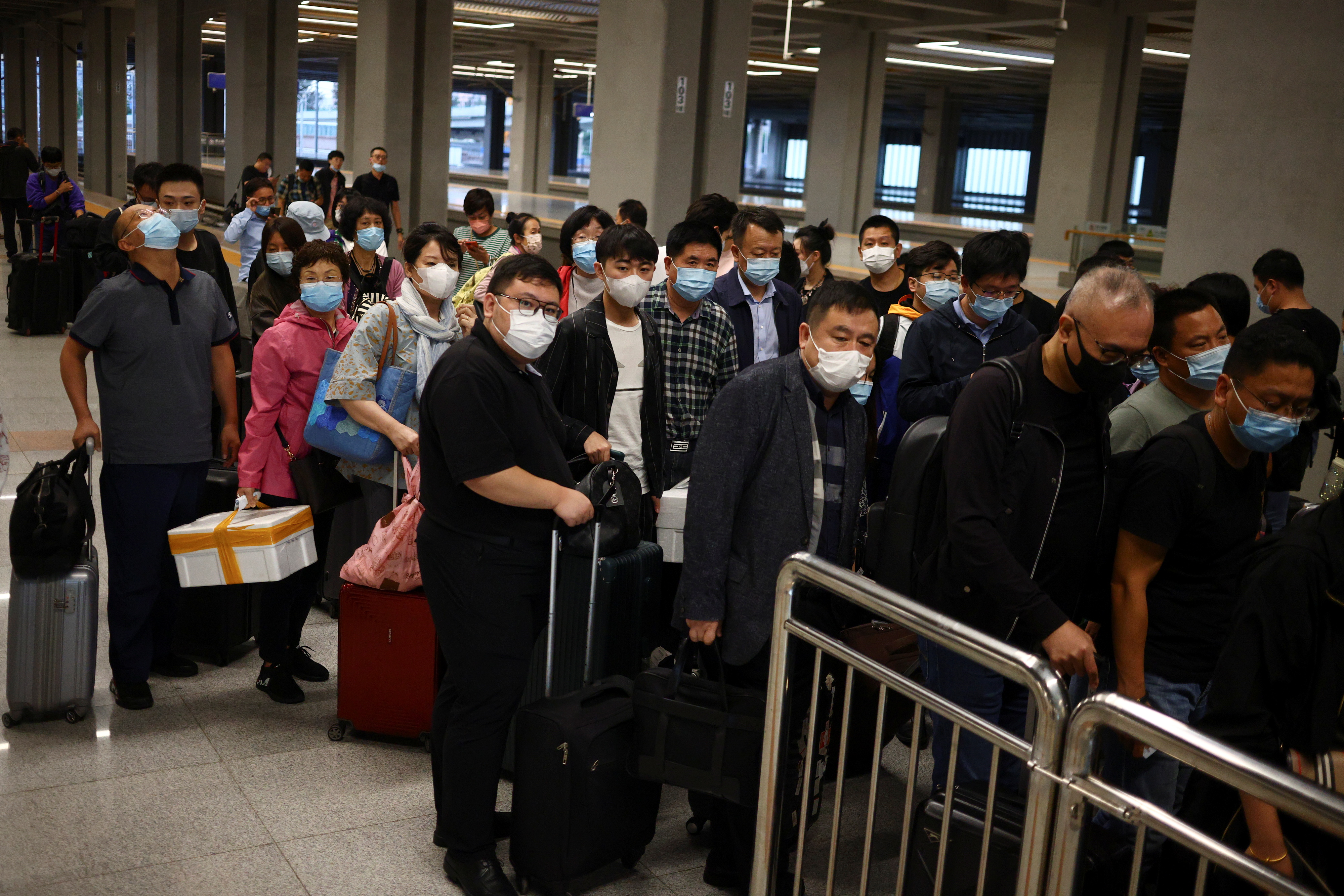 Travellers arrive at a train station ahead of China's upcoming Golden Week holiday following the coronavirus disease (COVID-19) outbreak, in Beijing