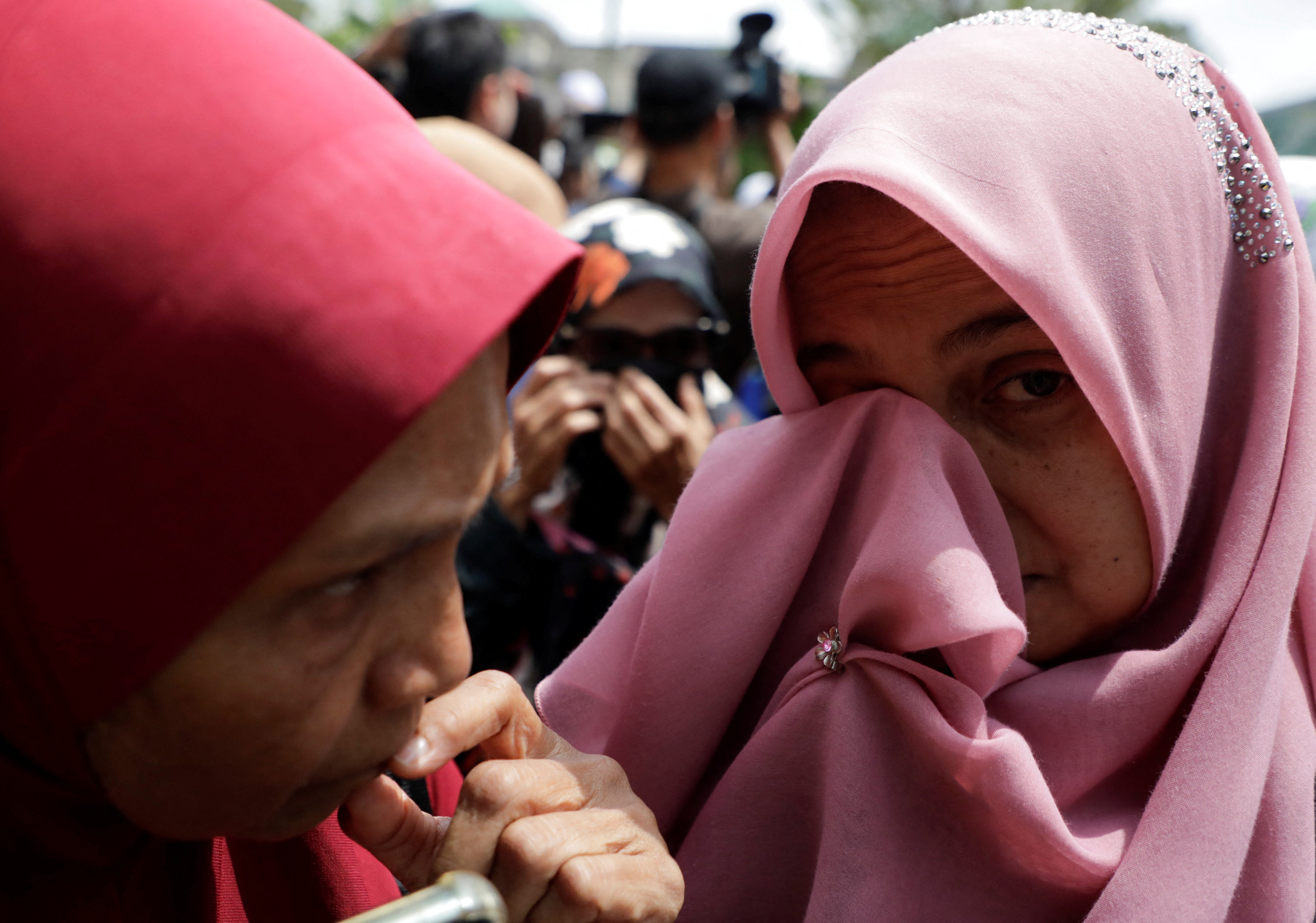 Former Malaysian Prime Minister Najib Razak's supporters wipe their tears at Putrajaya