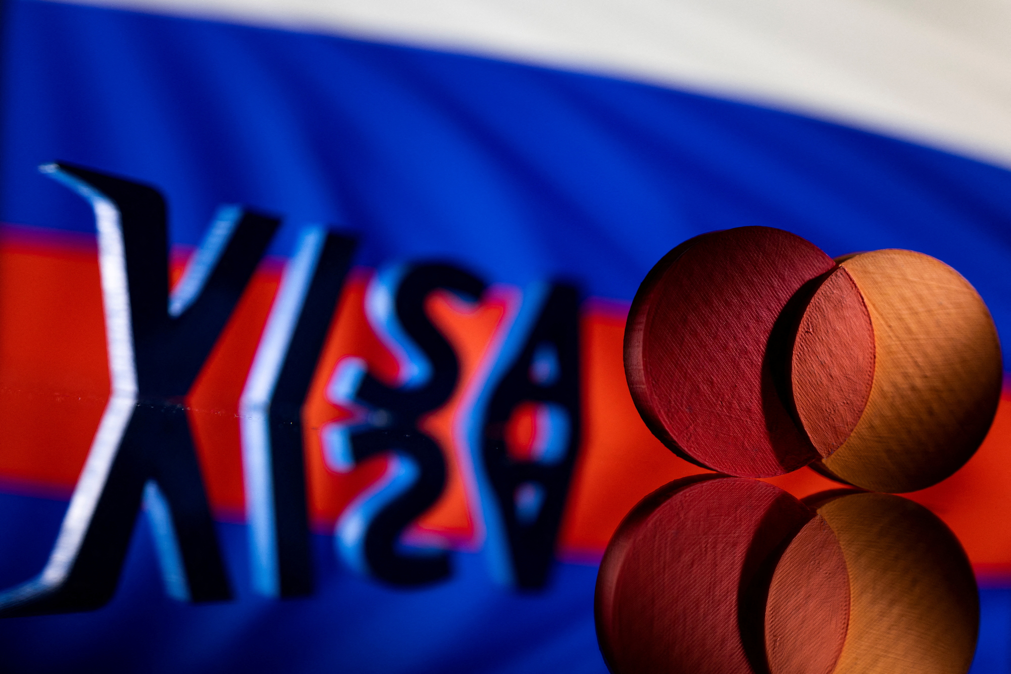 Illustration shows Visa and Mastercard logos in front of Russian flag