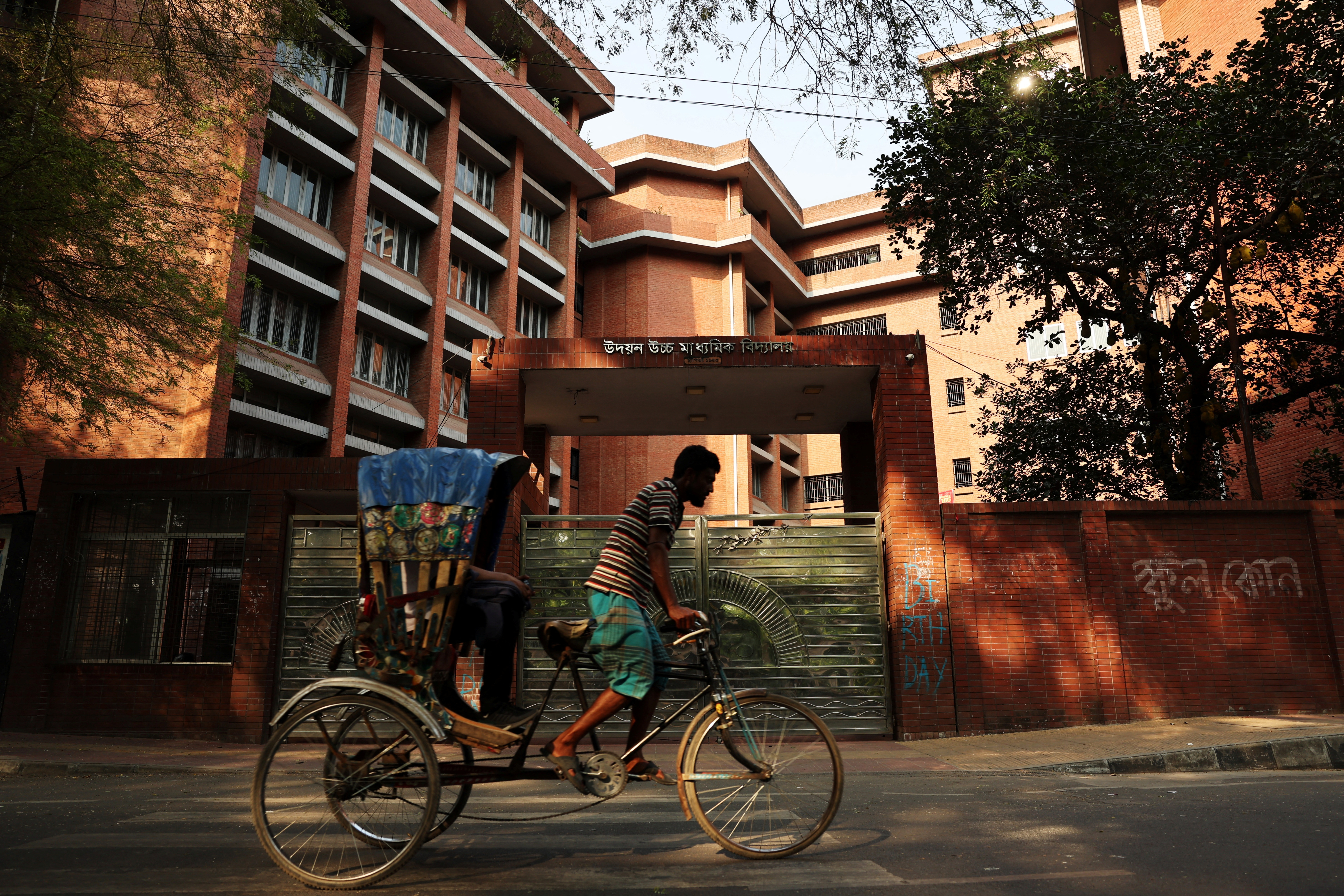 A rickshaw passes by a school named Udayan Uchcha Madhyamik Bidyalaya as all schools are closed due to on going heatwave in Dhaka