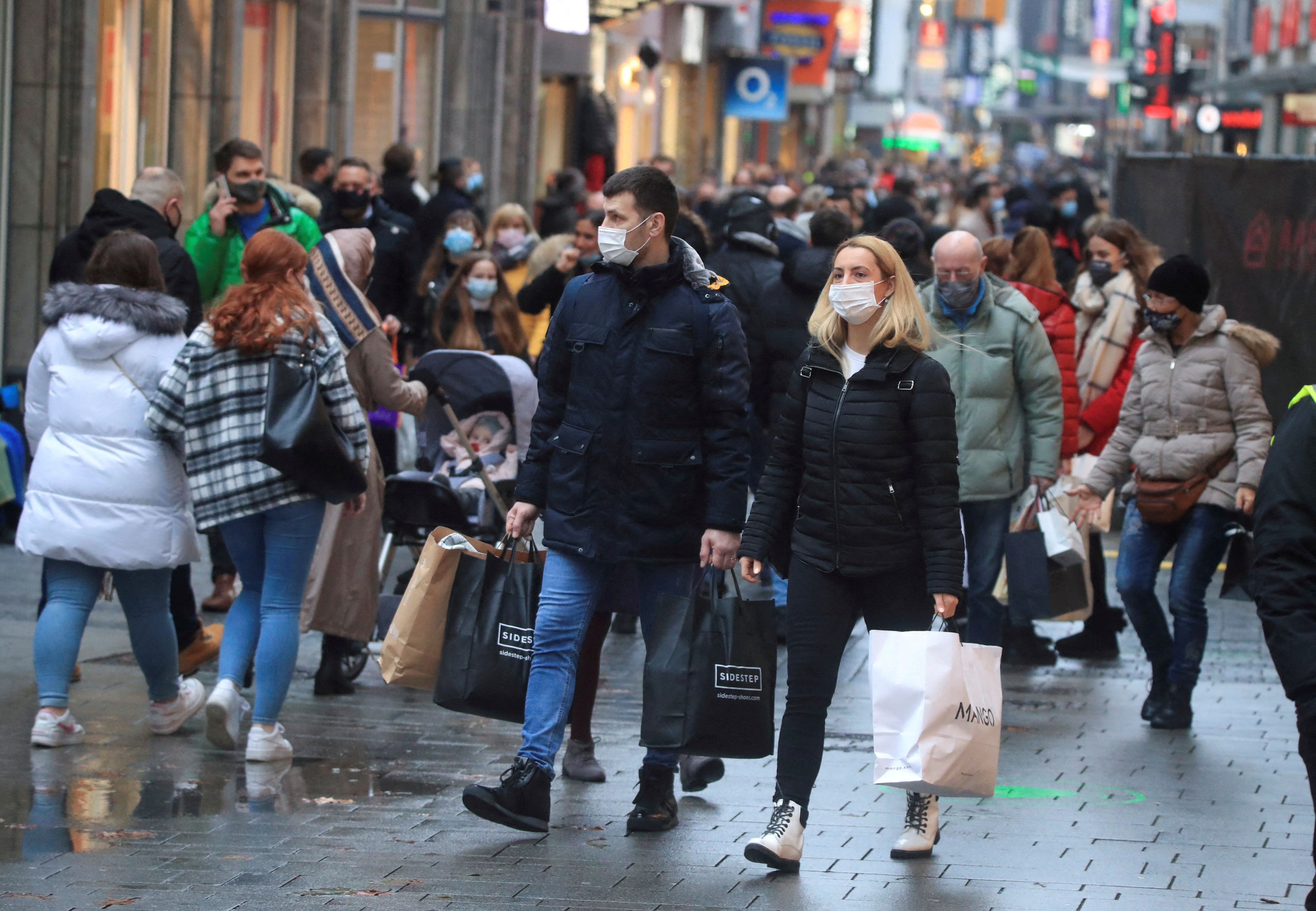 Christmas shoppers wear masks and fill Cologne's main shopping street Hohe Strasse (High Street) during the coronavirus disease (COVID-19) pandemic in Cologne
