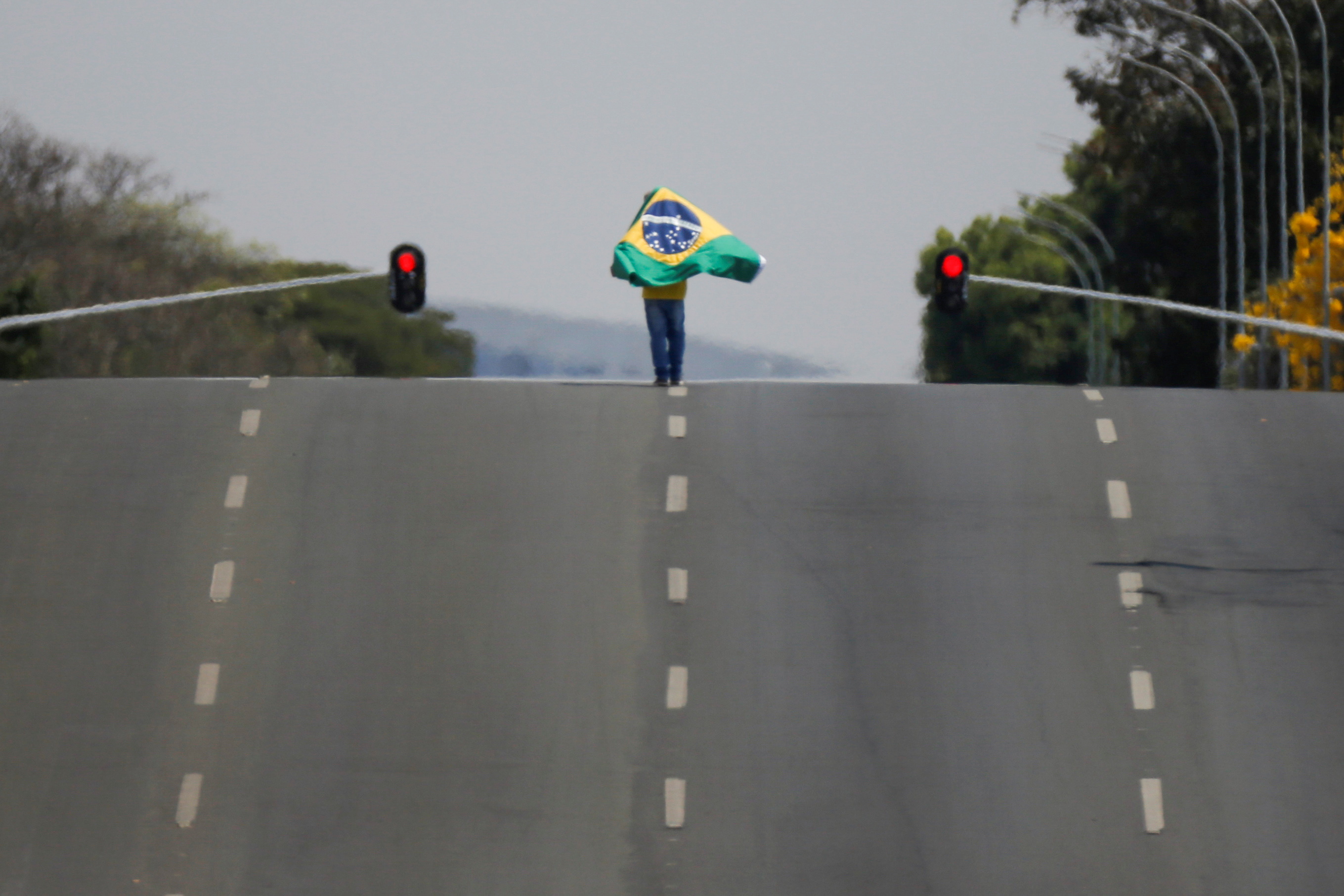 A supporter of Brazil's President Jair Bolsonaro walks with a flag during a demonstration outside the Planalto palace in Brasilia