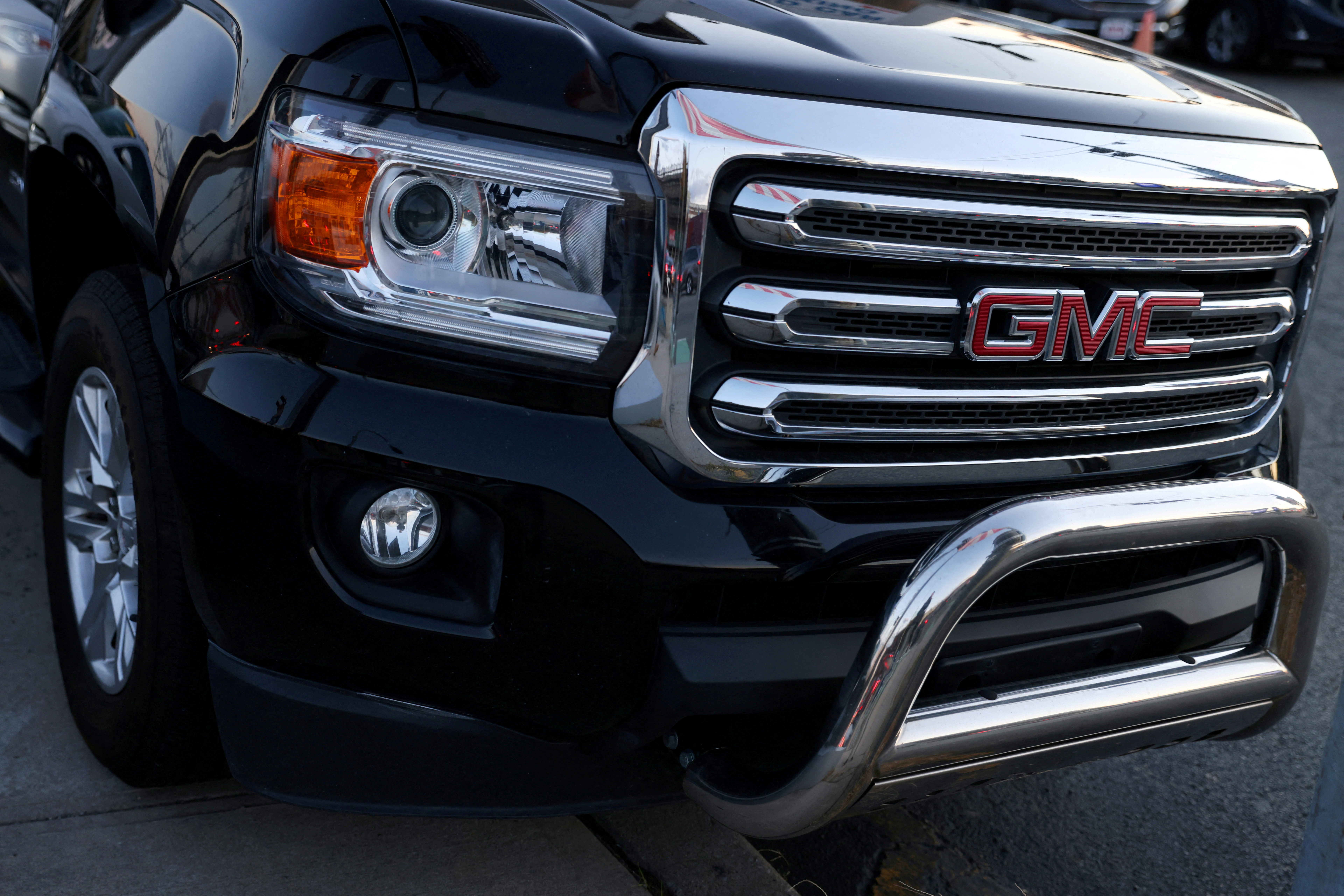 A badge of GMC, an automobile brand owned by General Motors Company, is seen on the grill of a vehicle for sale at a car dealership in Queens, New York