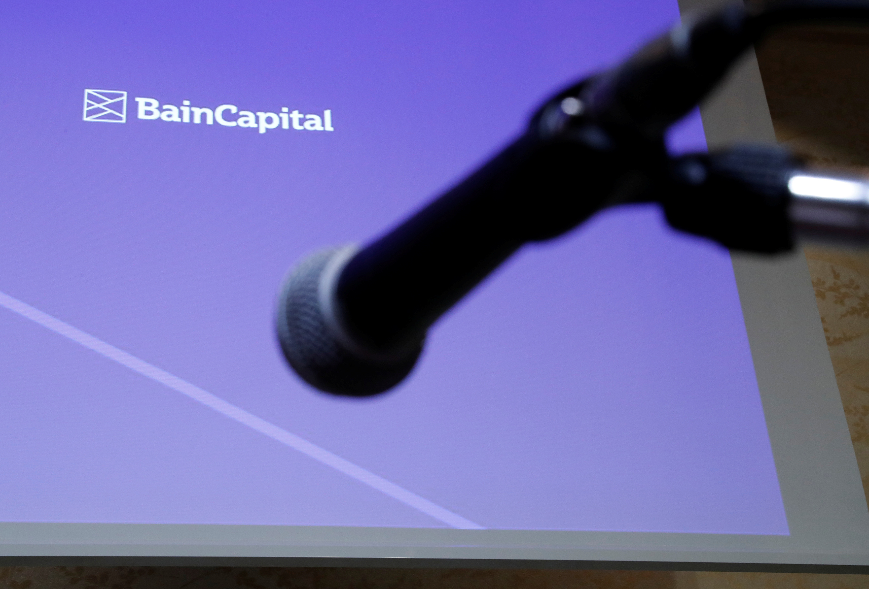 Logo of the Bain Capital is screened at a news conference in Tokyo