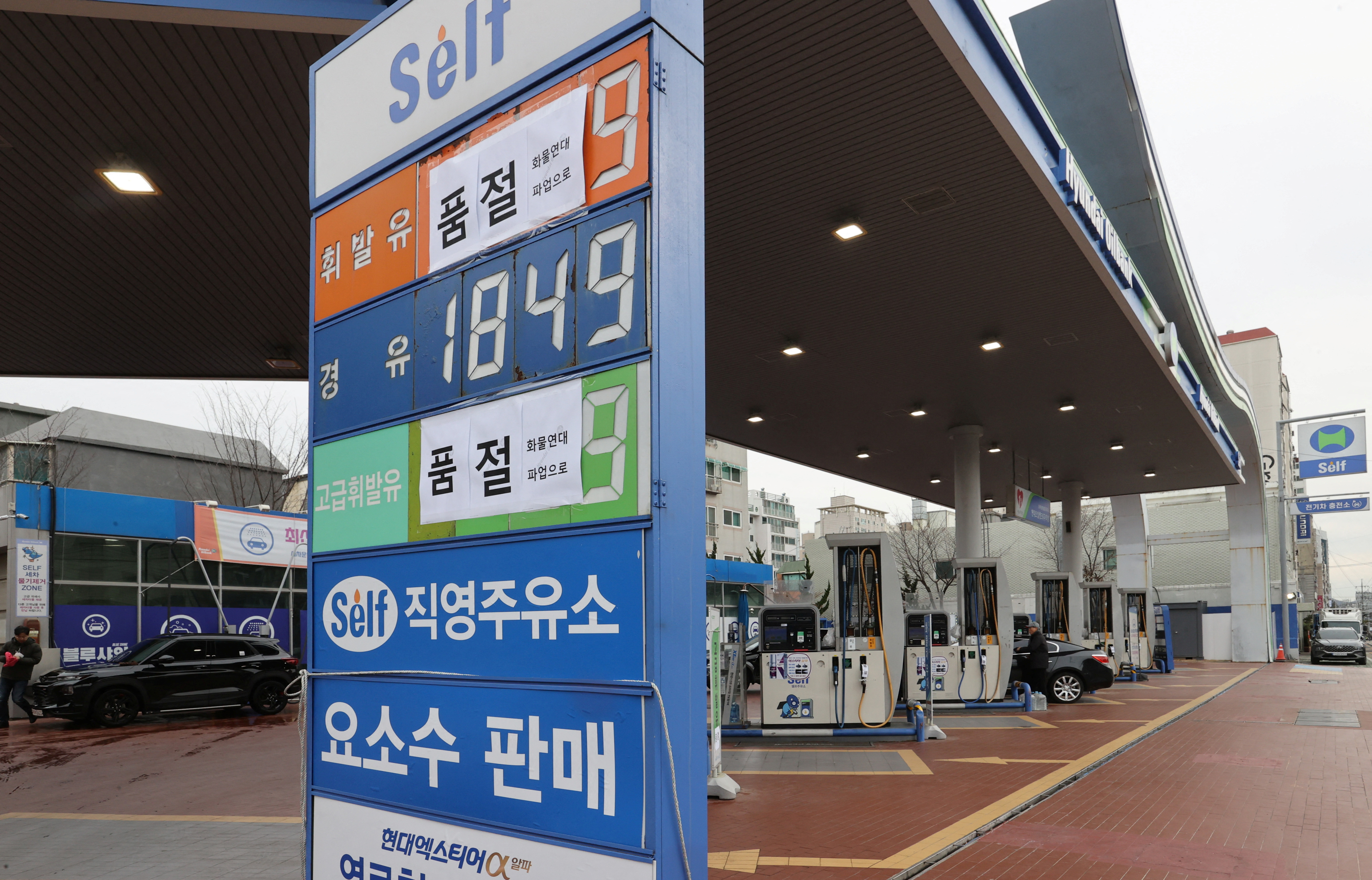 Signs reading 'Gasoline sold out, due to a strike by truckers' are seen at a gas station in Seoul