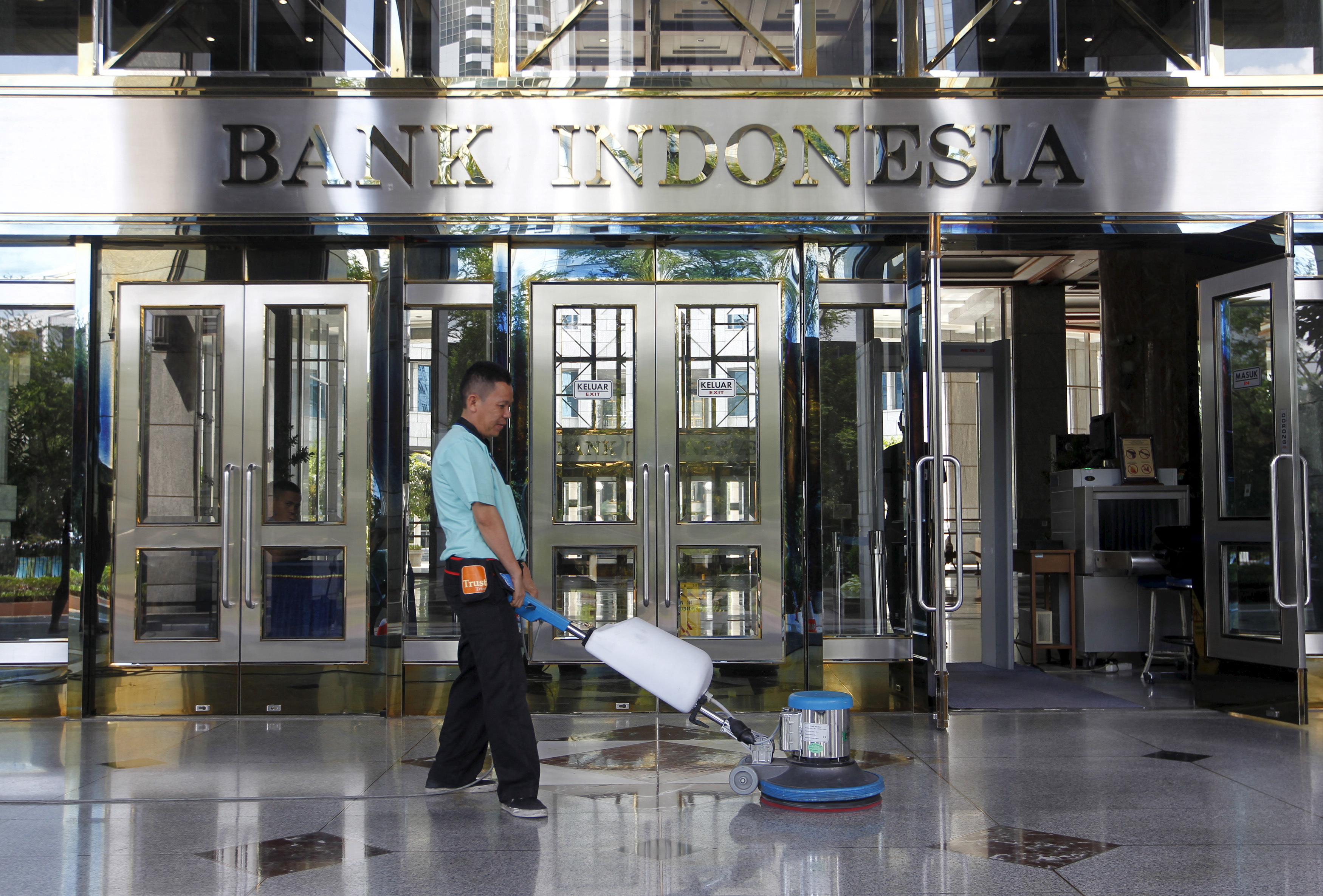 A worker cleans near the front entrance of the Bank Indonesia's headquarters in Jakarta, Indonesia