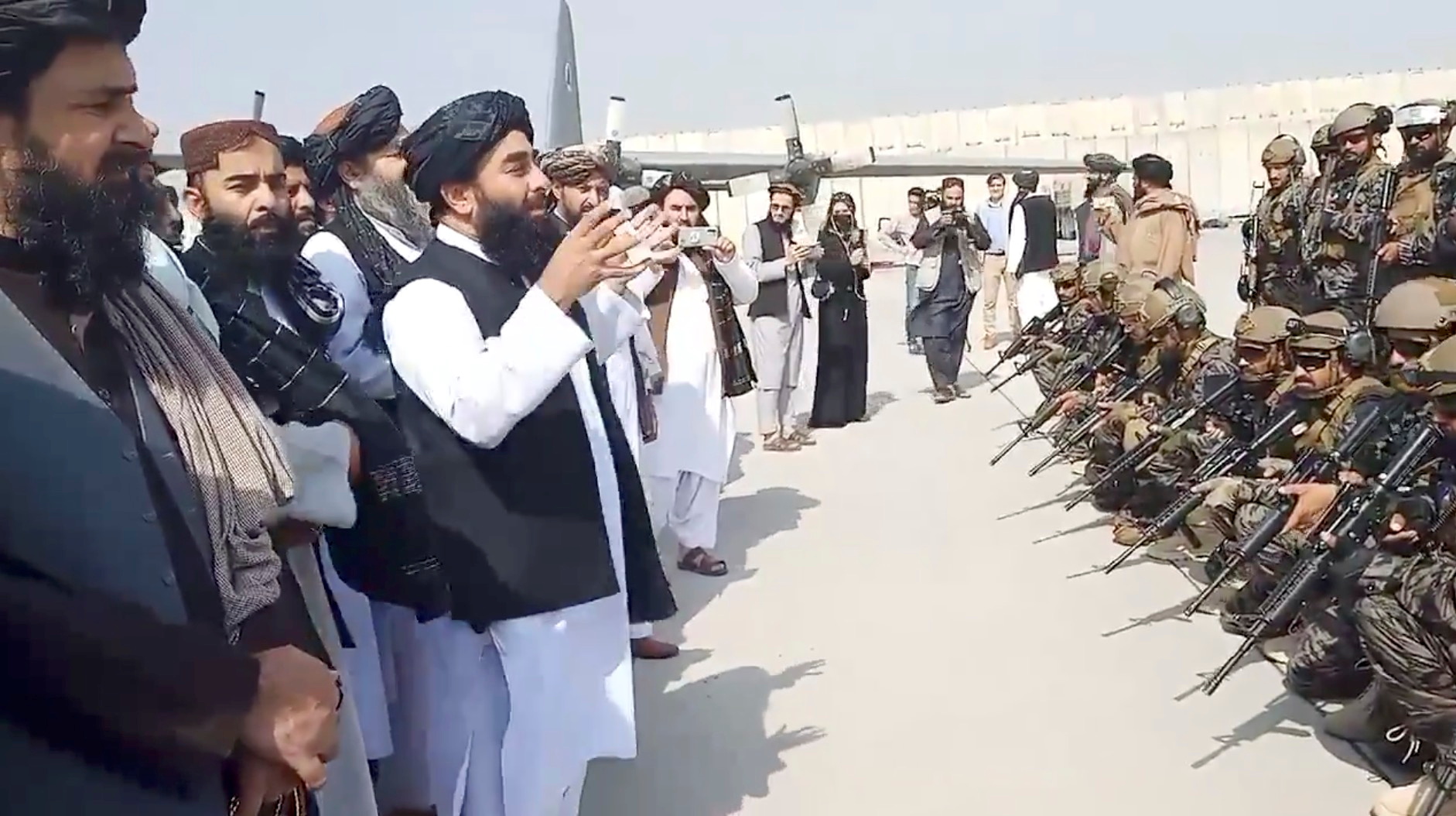 Taliban spokesman Zabihullah Mujahid speaks to Badri 313 military unit at Kabul's airport, Afghanistan August 31, 2021 in this still image obtained from a handout video.  Taliban/Handout via REUTERS   