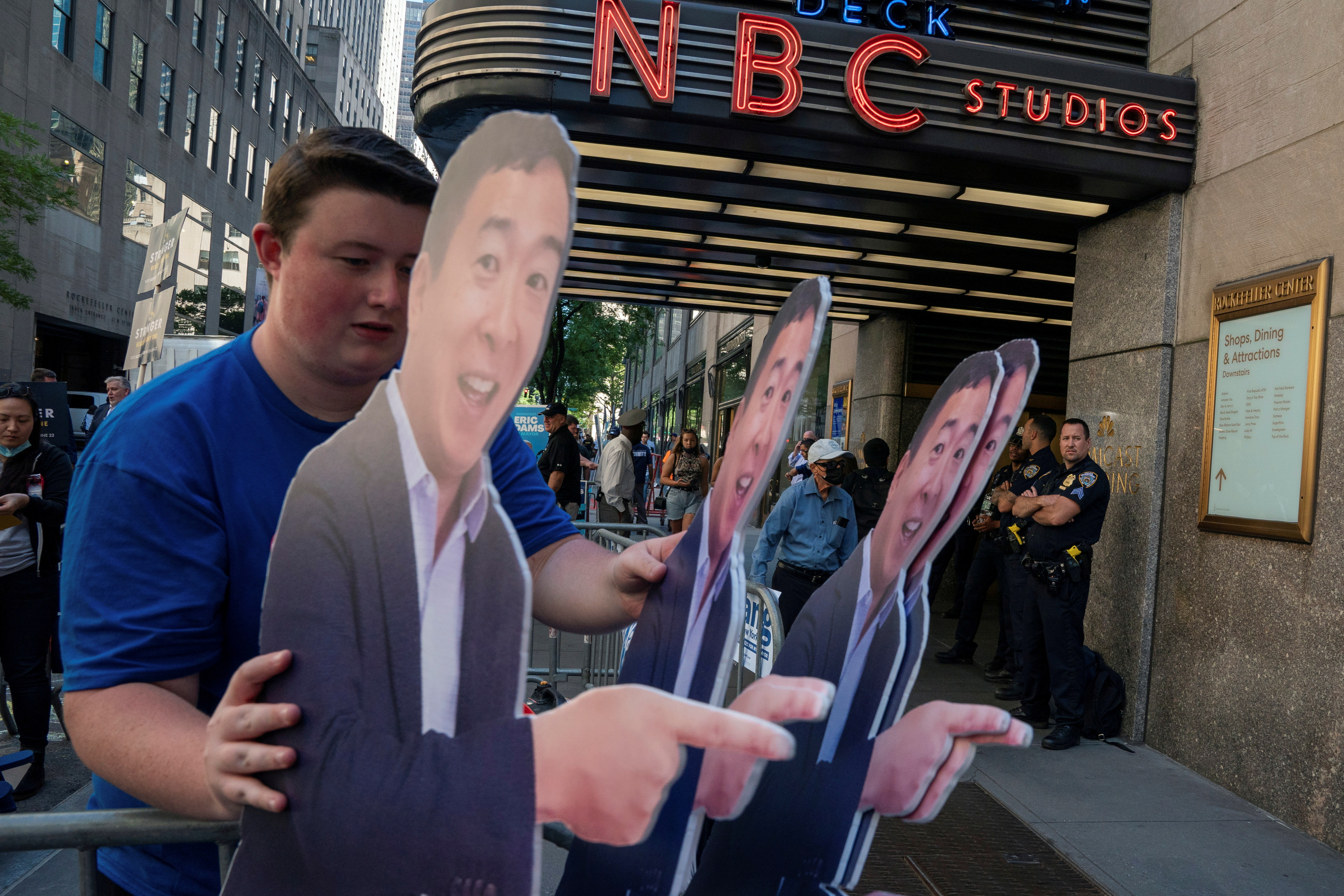 A supporter carries life size cutouts of New York City Mayoral hopeful Andrew Yang at the Democratic primary debate in New York City