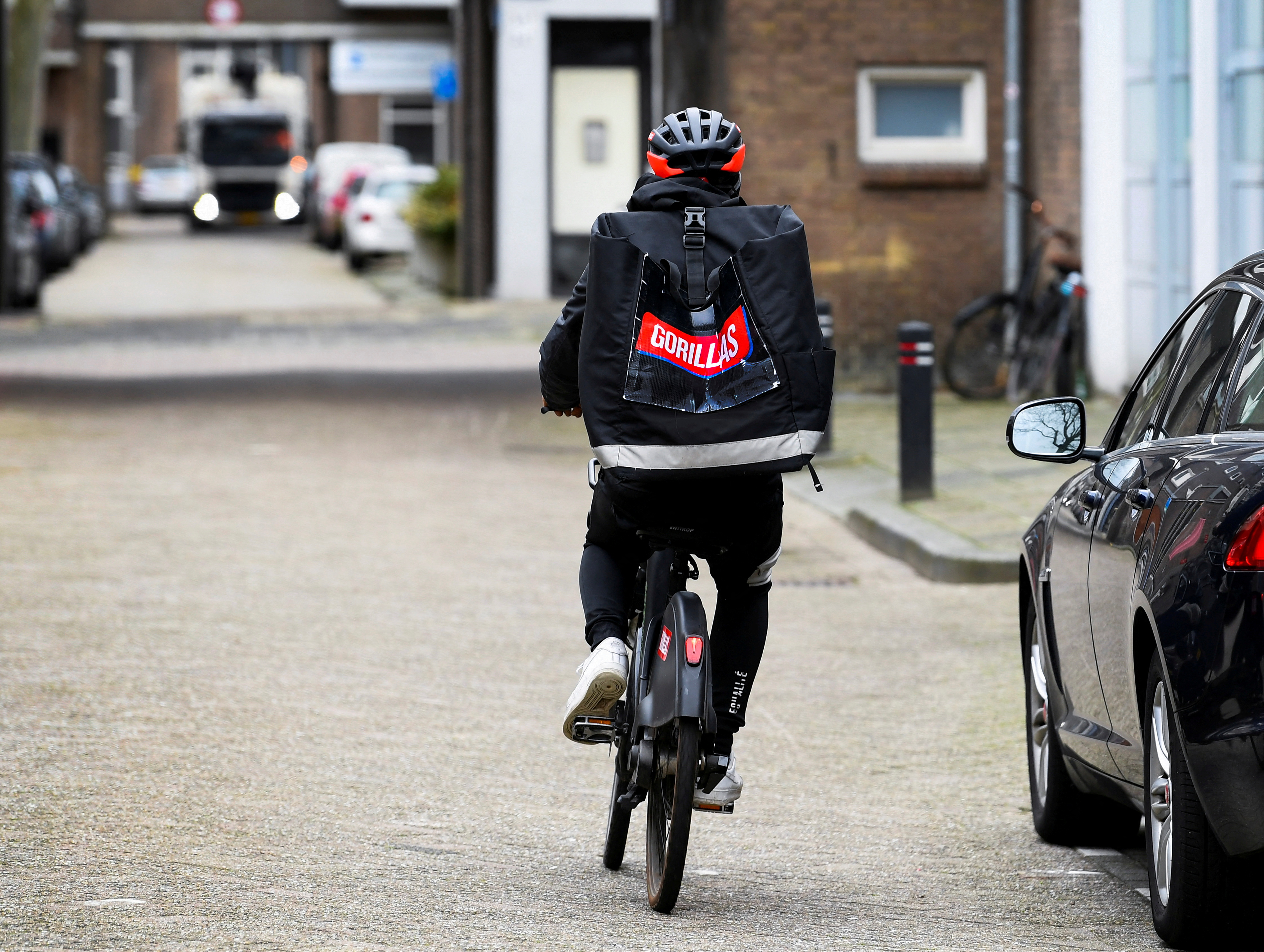 A courier of the fast grocery deliverer Gorillas rides a bike in Rotterdam, Netherlands