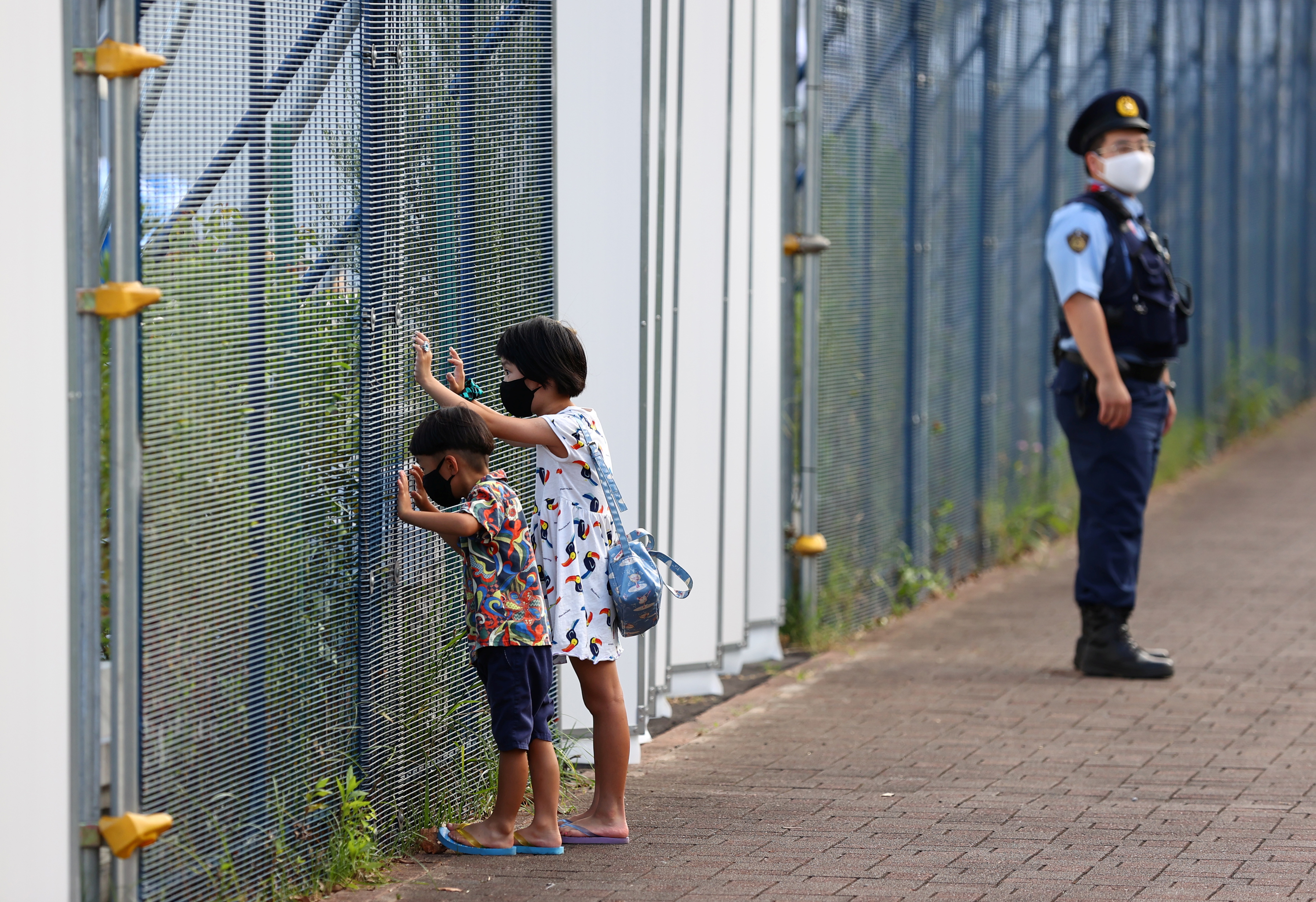 Children look through fence of Aomi Urban Sports Park in Tokyo