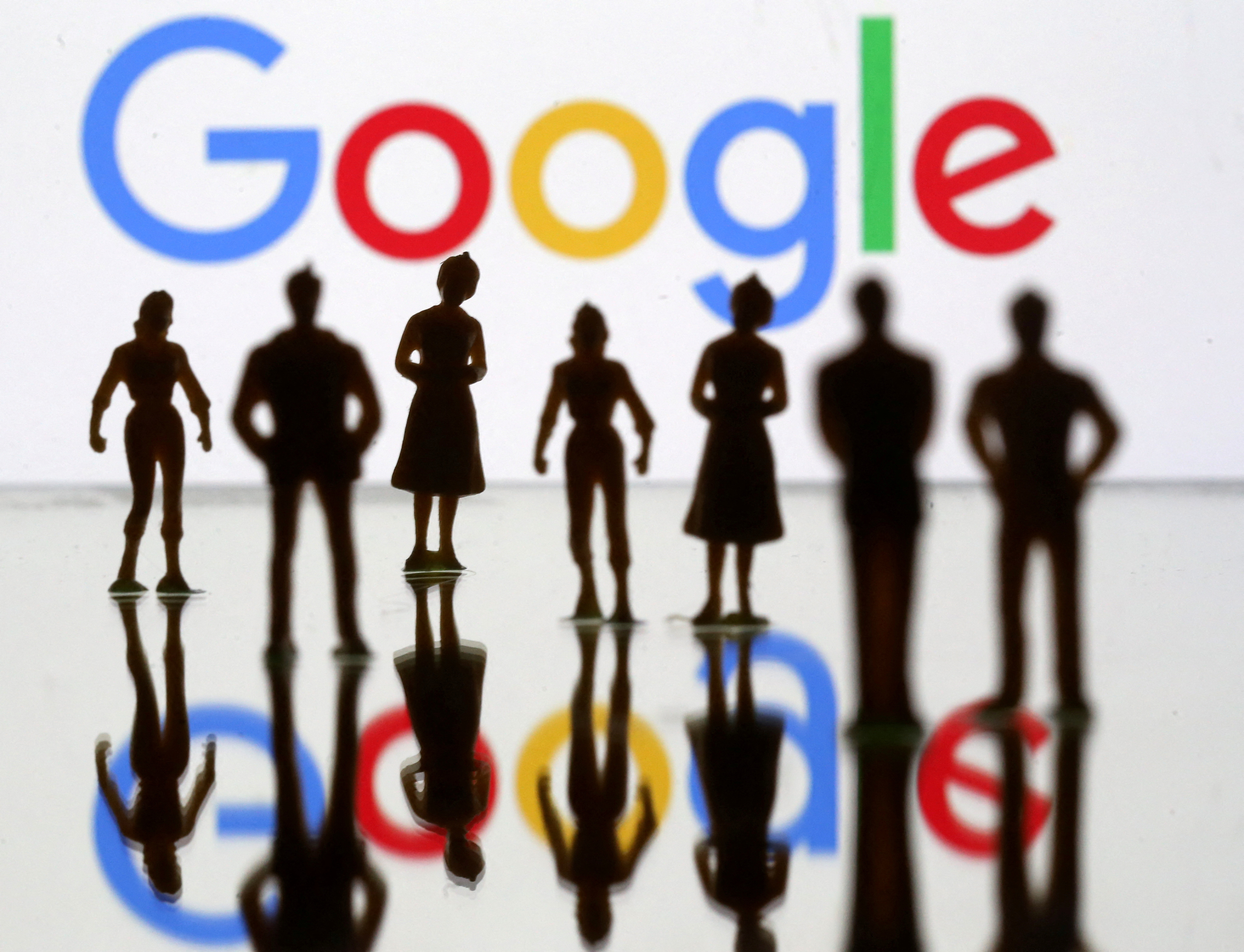Small toy figures are seen in front of Google logo in this illustration picture
