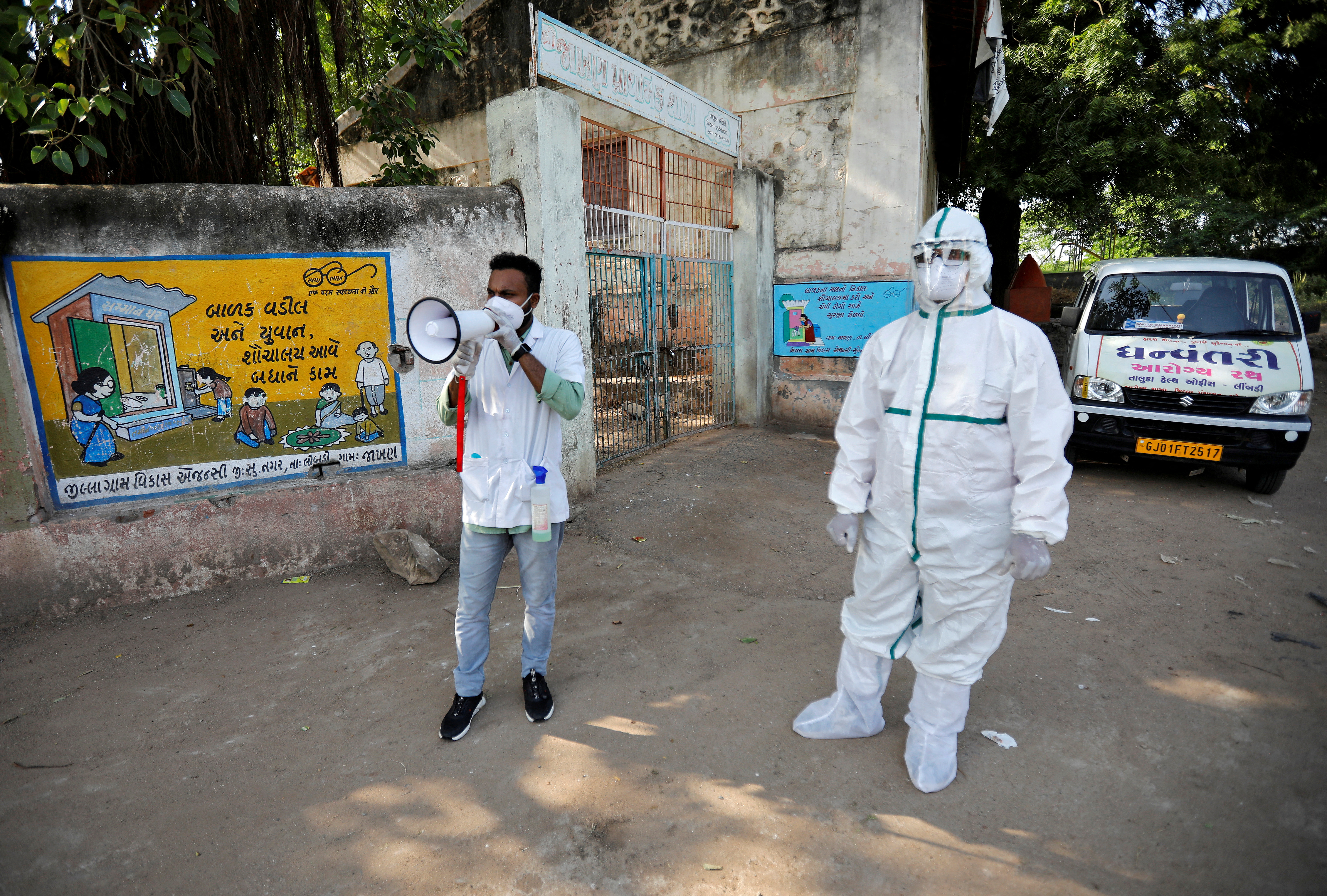 A healthcare worker announces to people to get their rapid antigen tests done during a door-to-door survey for the coronavirus disease (COVID-19), in Jakhan village in the western state of Gujarat, India, September 22, 2020. REUTERS/Amit Dave/File Photo